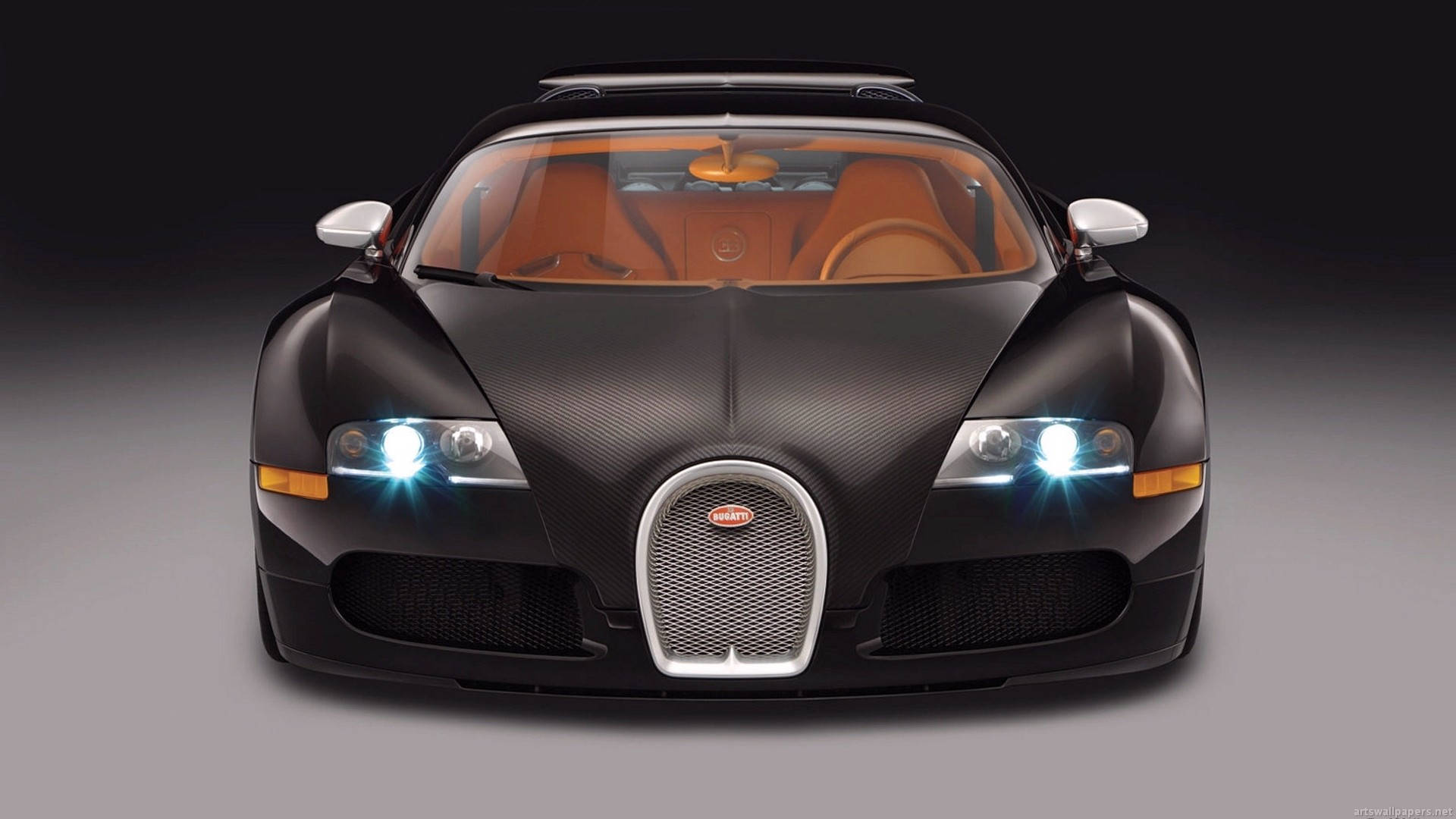 優雅車款品牌布加迪 壁紙 — 一輛時尚的黑色Bugatti Veyron，採用碳纖維車身和發光頭燈，在黑暗的攝影棚背景下正面朝前。