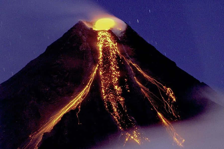 充滿岩漿的火山美景 壁紙 — 火山在夜間爆發，發光的熔岩沿著黑暗的山坡流下，星空下。