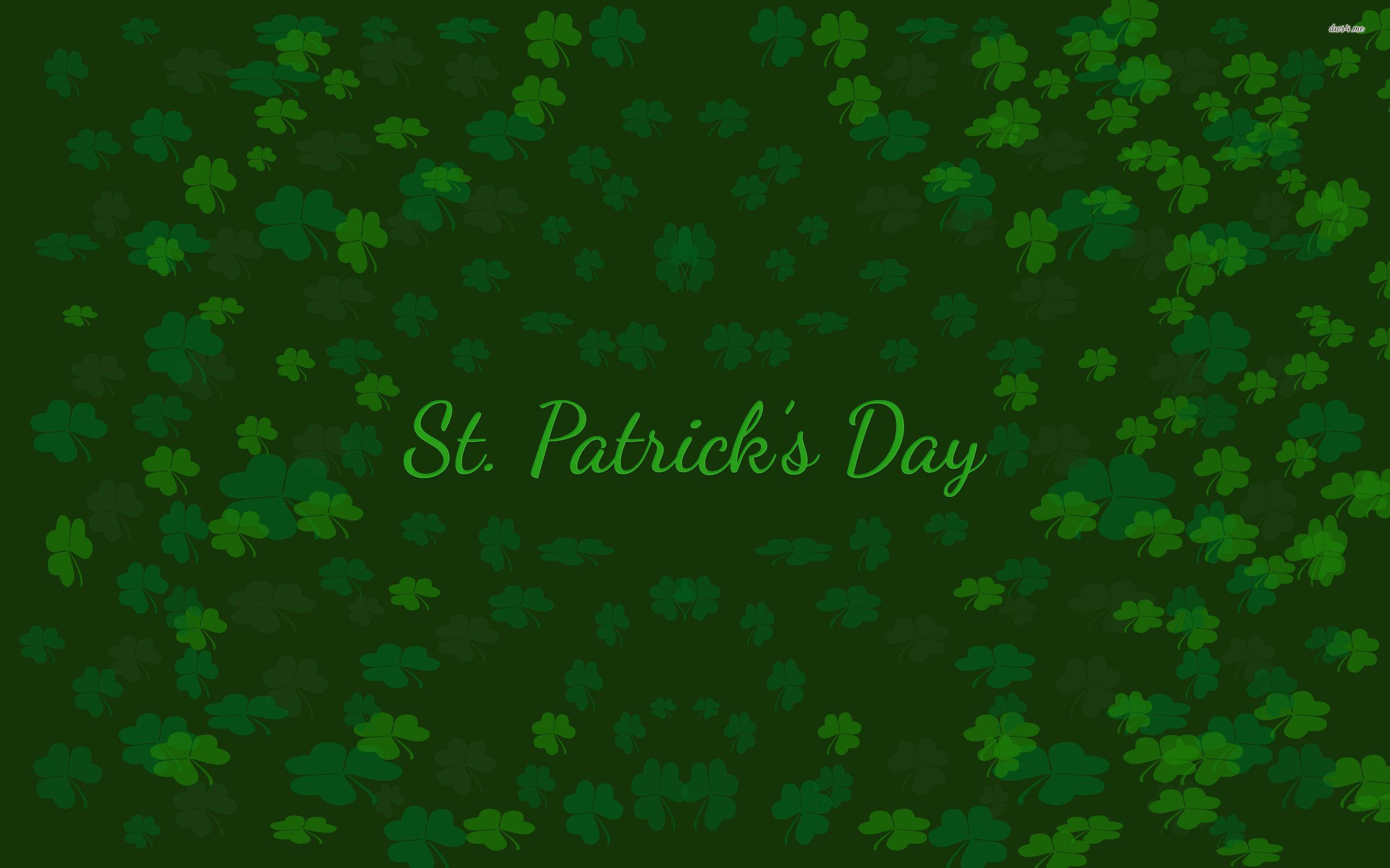 St Patricks Day Birthday 桌布 壁紙 — 充滿散落三葉草和草書聖帕特里克節文字的節日綠色背景。