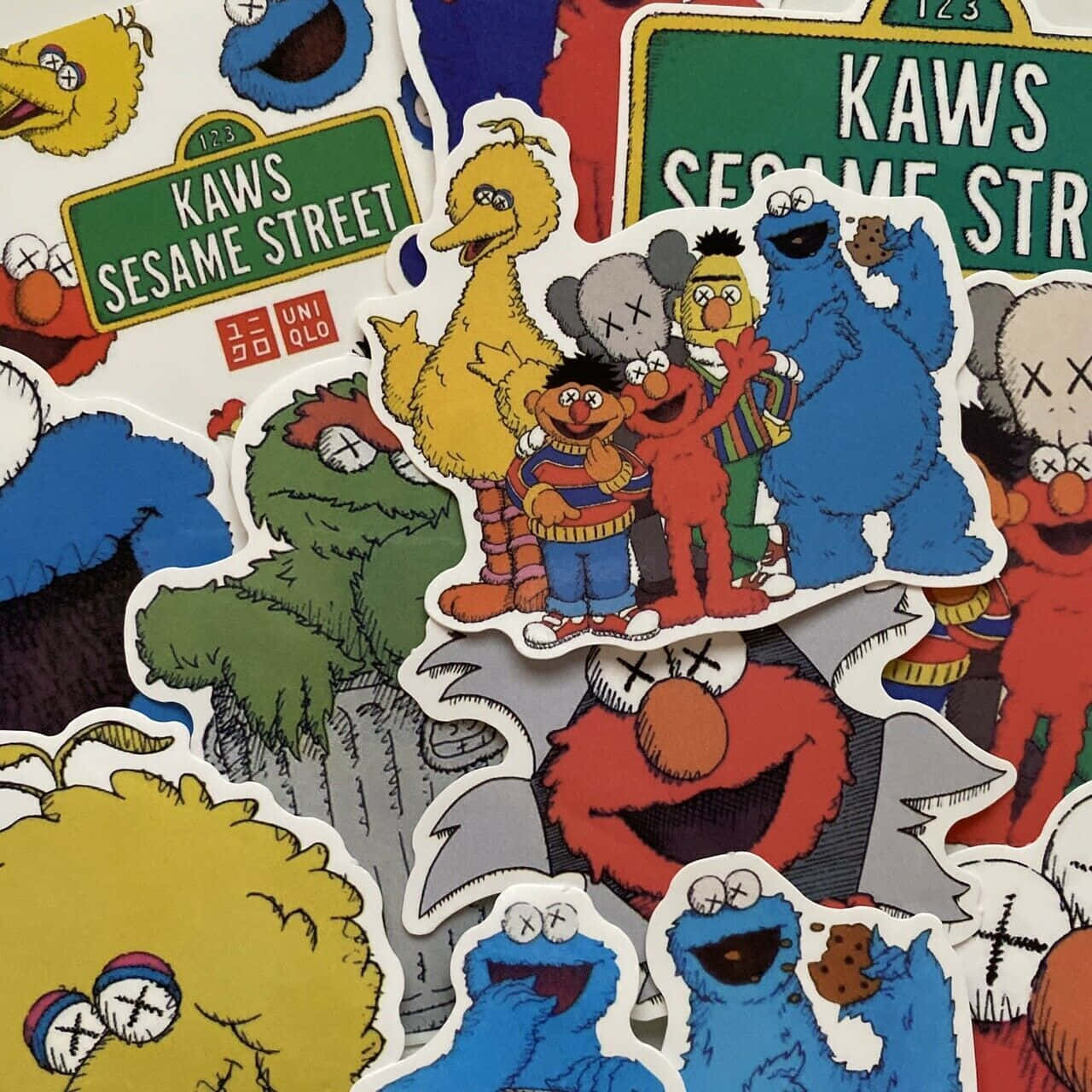 Kaws Sesame Street 桌布 壁紙 — 充滿活力的KAWS x Sesame Street貼紙拼貼， featuring 角色如Elmo、Cookie Monster和Big Bird，帶有標誌性的X眼睛設計。