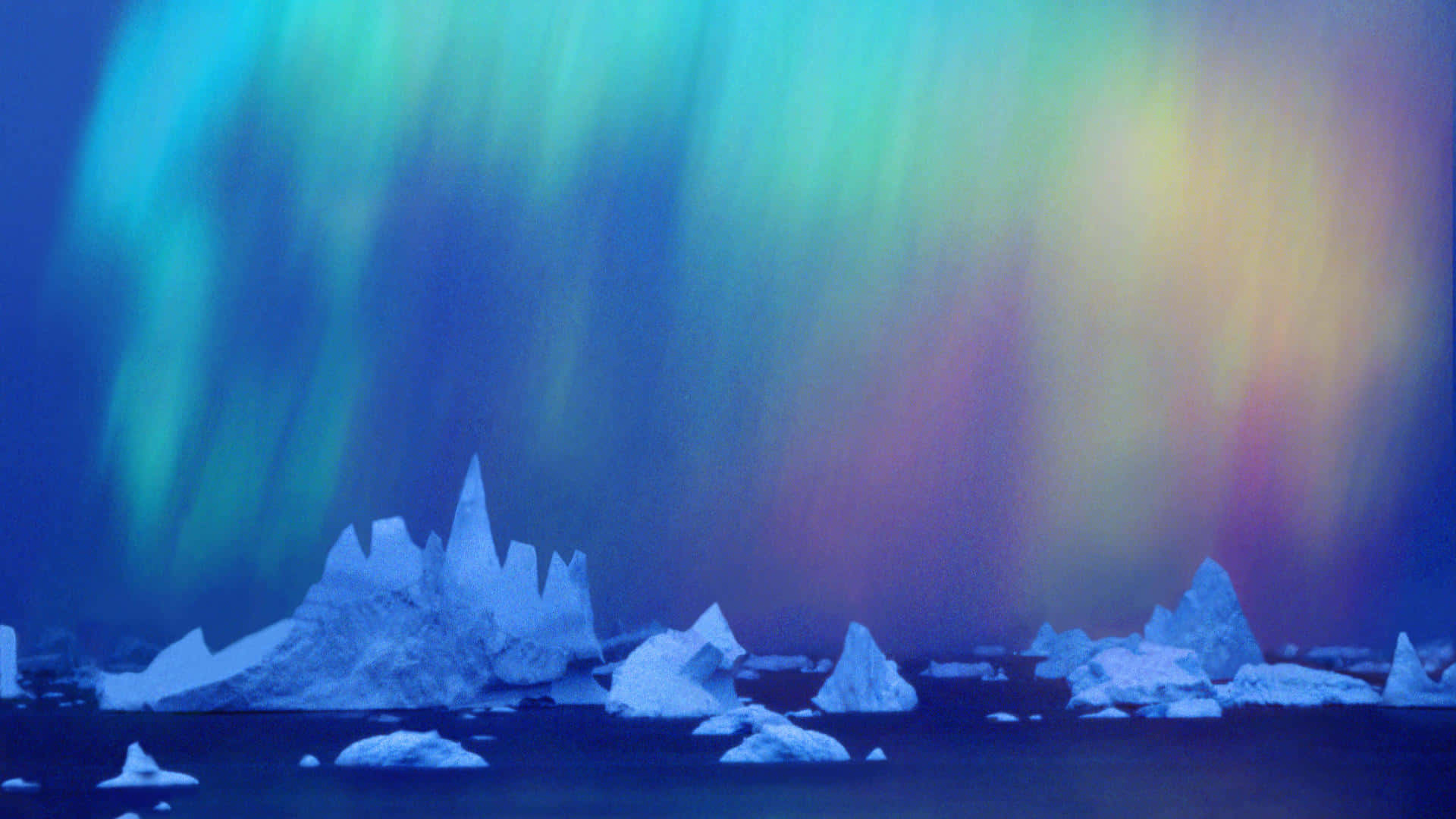 Antarctica 桌布 壁紙 — 充滿活力的北極光在黑暗的北極海上漂浮的鋸齒狀冰山上舞動，呈現出電光綠和紫色。