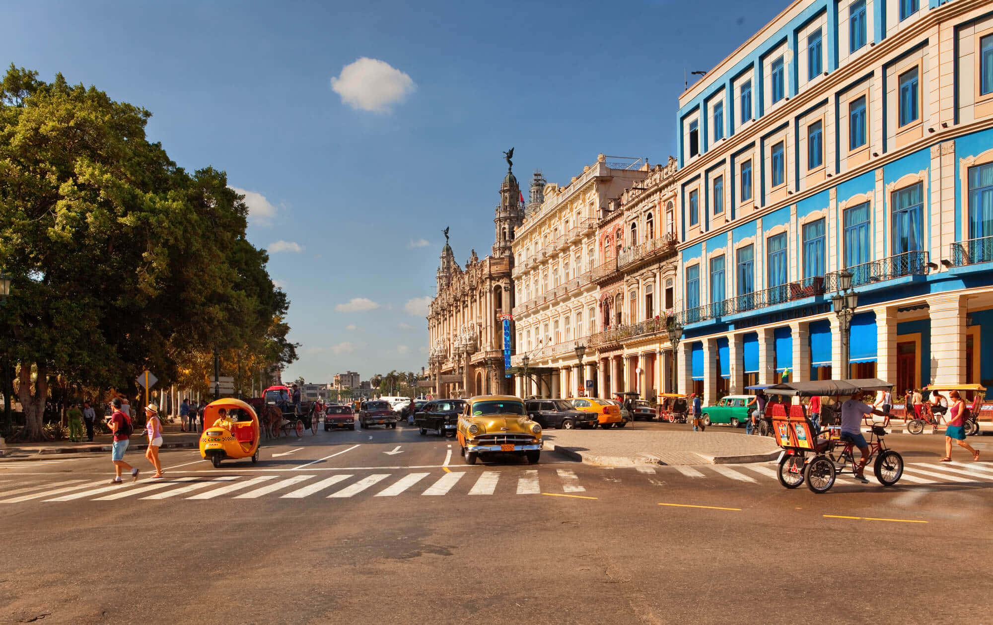 Cuba 桌布 壁紙 — 充滿活力的夏灣拿街景，經典黃色汽車和色彩繽紛的殖民建築在明亮的藍天下。