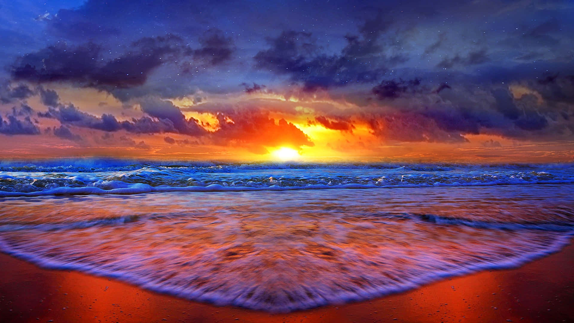 海灘日落 桌布 壁紙 — 充滿活力的夕陽將海洋和天空染成火熱的橙色和深紫色，海浪拍打著發光的紅色海灘。