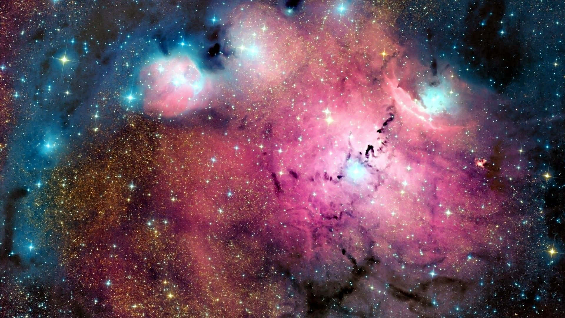 Pink Galaxy 桌布 壁紙 — 充滿活力的宇宙星雲在星空背景下以粉紅、藍色和金色旋轉。