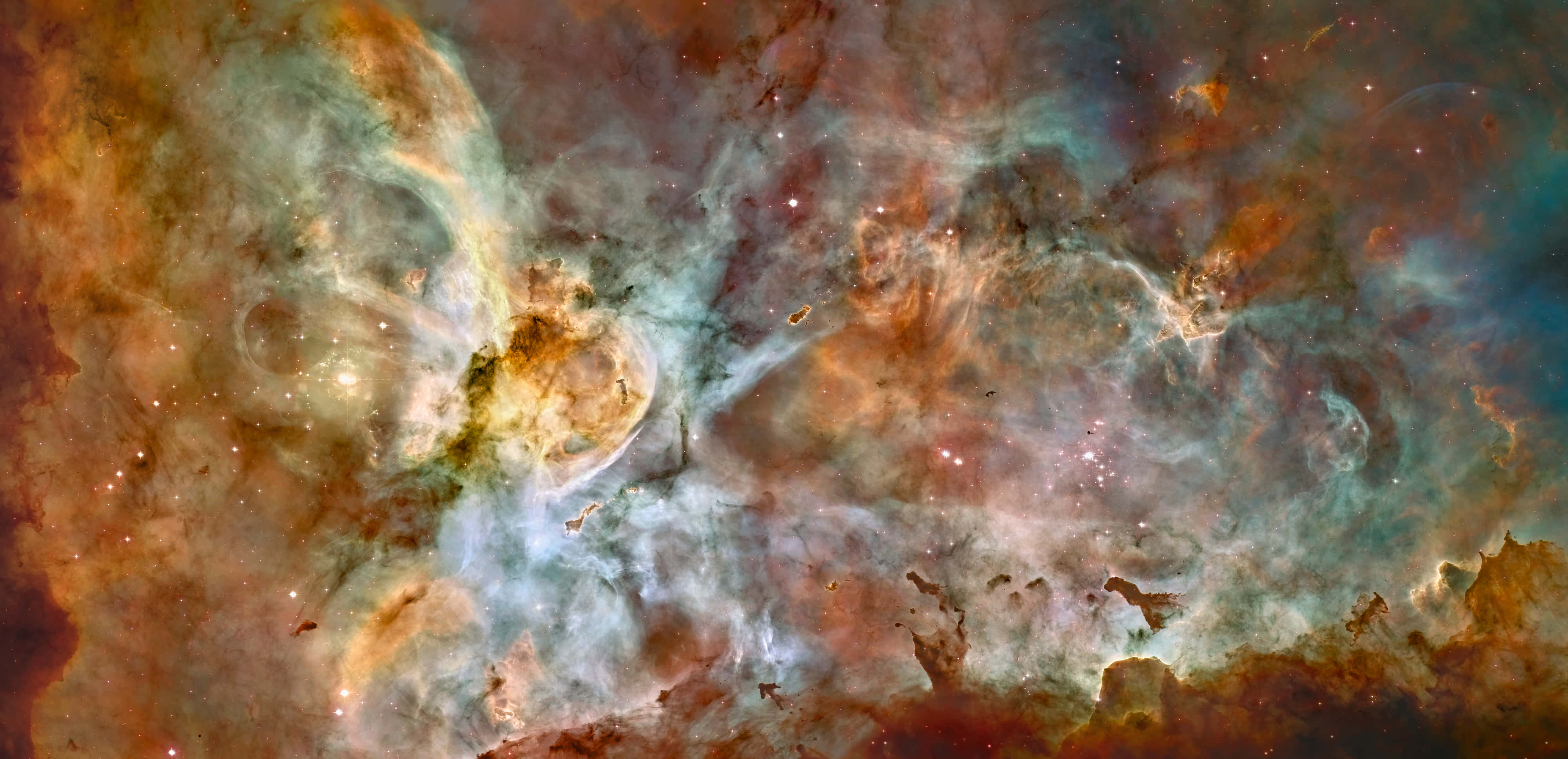 Carina Nebula 桌布 壁紙 — 充滿活力的宇宙雲層在熾熱的橙色和冷藍色中旋轉，散落的星星在令人嘆為觀止的星雲中閃耀。