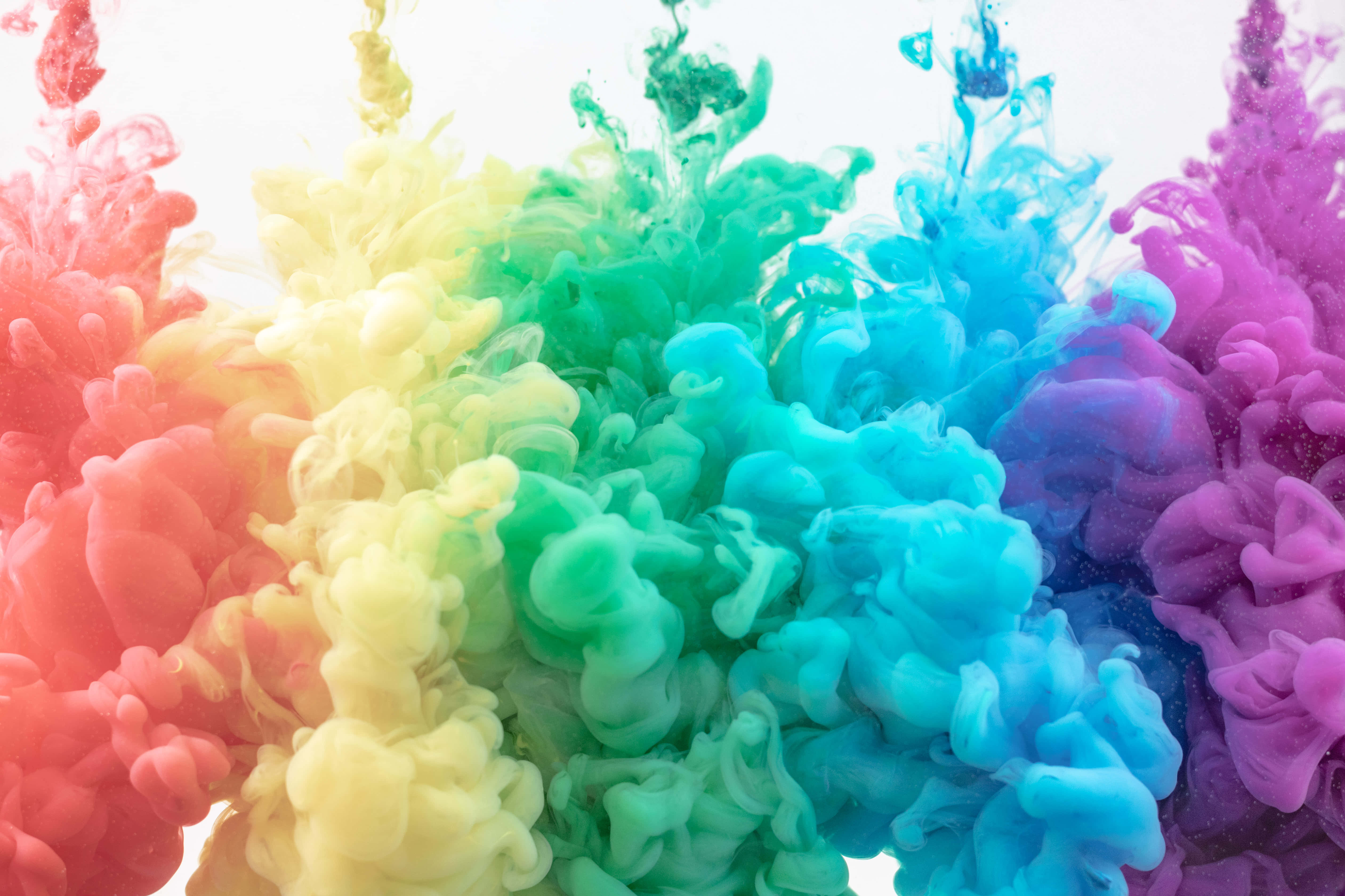 Beautiful Color 桌布 壁紙 — 充滿活力的彩虹墨水漩渦在明亮的白色背景上像雲一樣爆發。