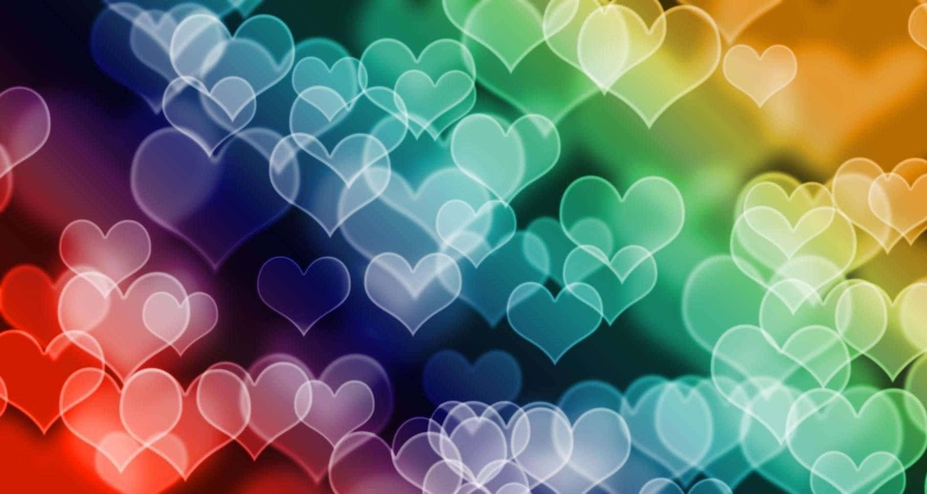 Rainbow Heart 桌布 壁紙 — 充滿活力的彩虹散景心形在夢幻般的漸變背景上柔和地發光。