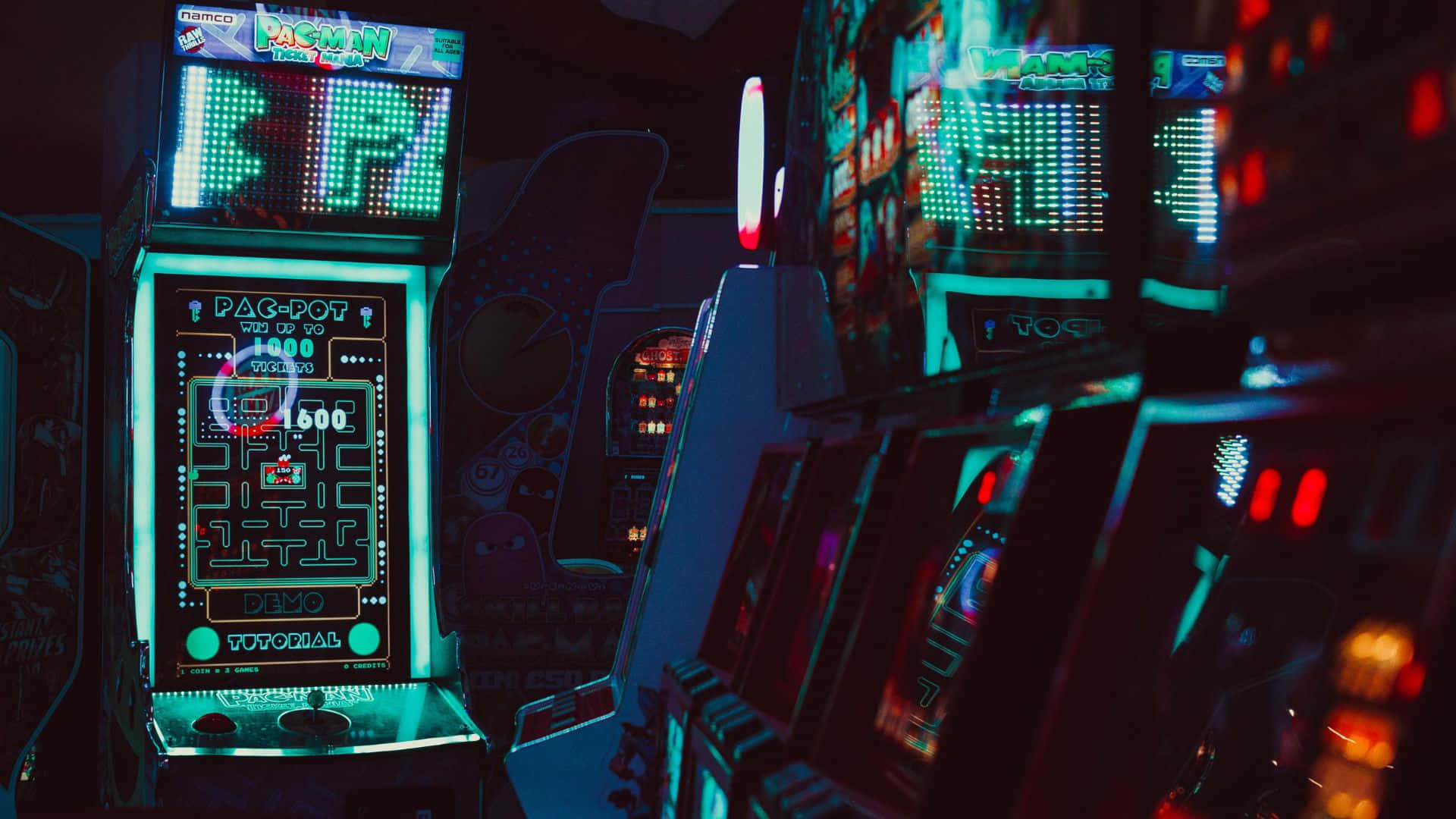HD Gaming 桌布 壁紙 — 充滿活力的復古街機在昏暗的遊戲小巷中閃爍著霓虹燈光。