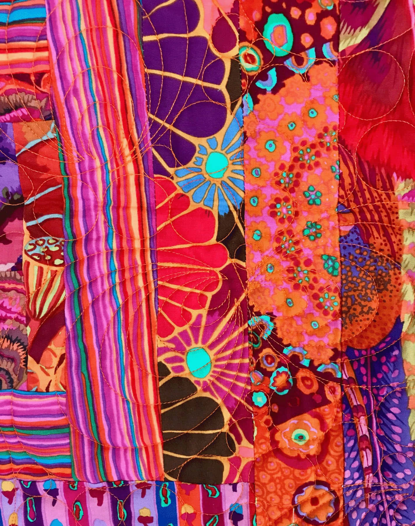 Textile Art 桌布 壁紙 — 充滿活力的拼布被，以鮮豔的粉紅色、橙色、紫色和藍綠色縫製出大膽的花卉和條紋圖案。