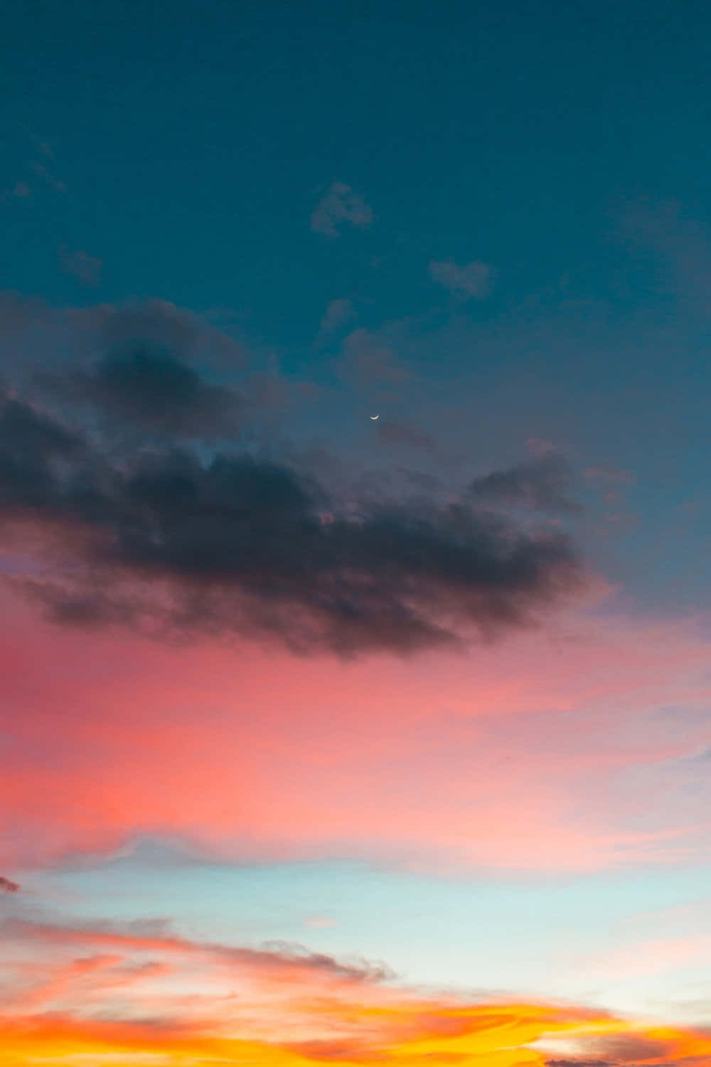 Sunset Photography 桌布 壁紙 — 充滿活力的日落天空，火橙色雲彩在上弦月上方融合成粉紅色和藍綠色。