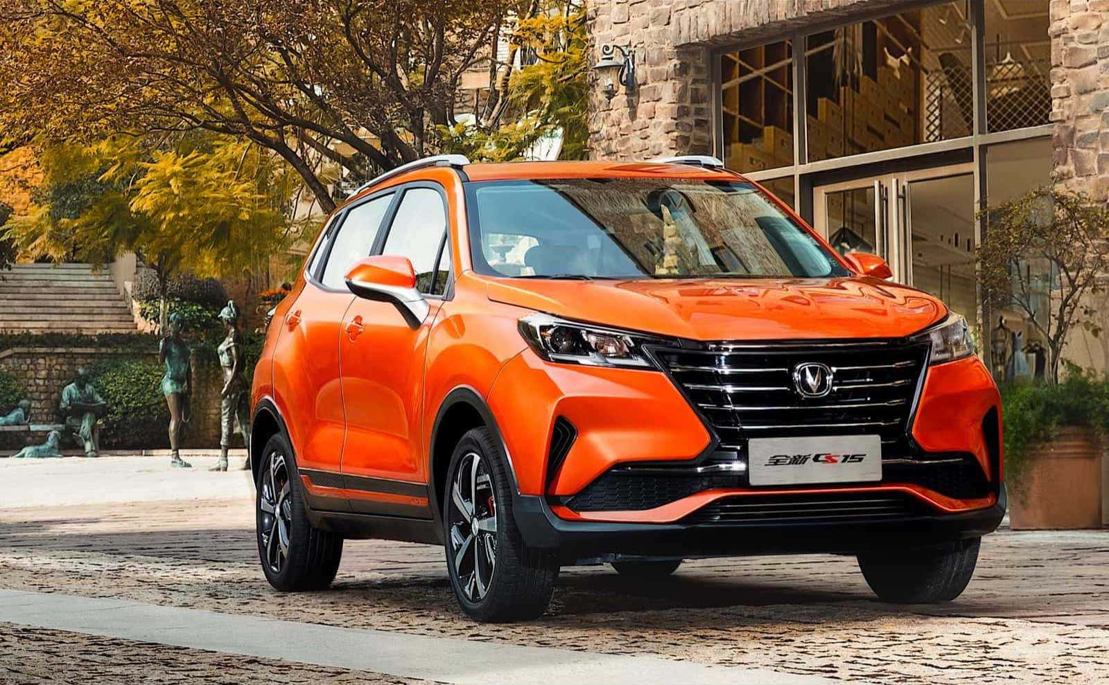 Changan 桌布 壁紙 — 充滿活力的橙色SUV停泊在鵝卵石街道上，旁邊是秋樹和石建築。
