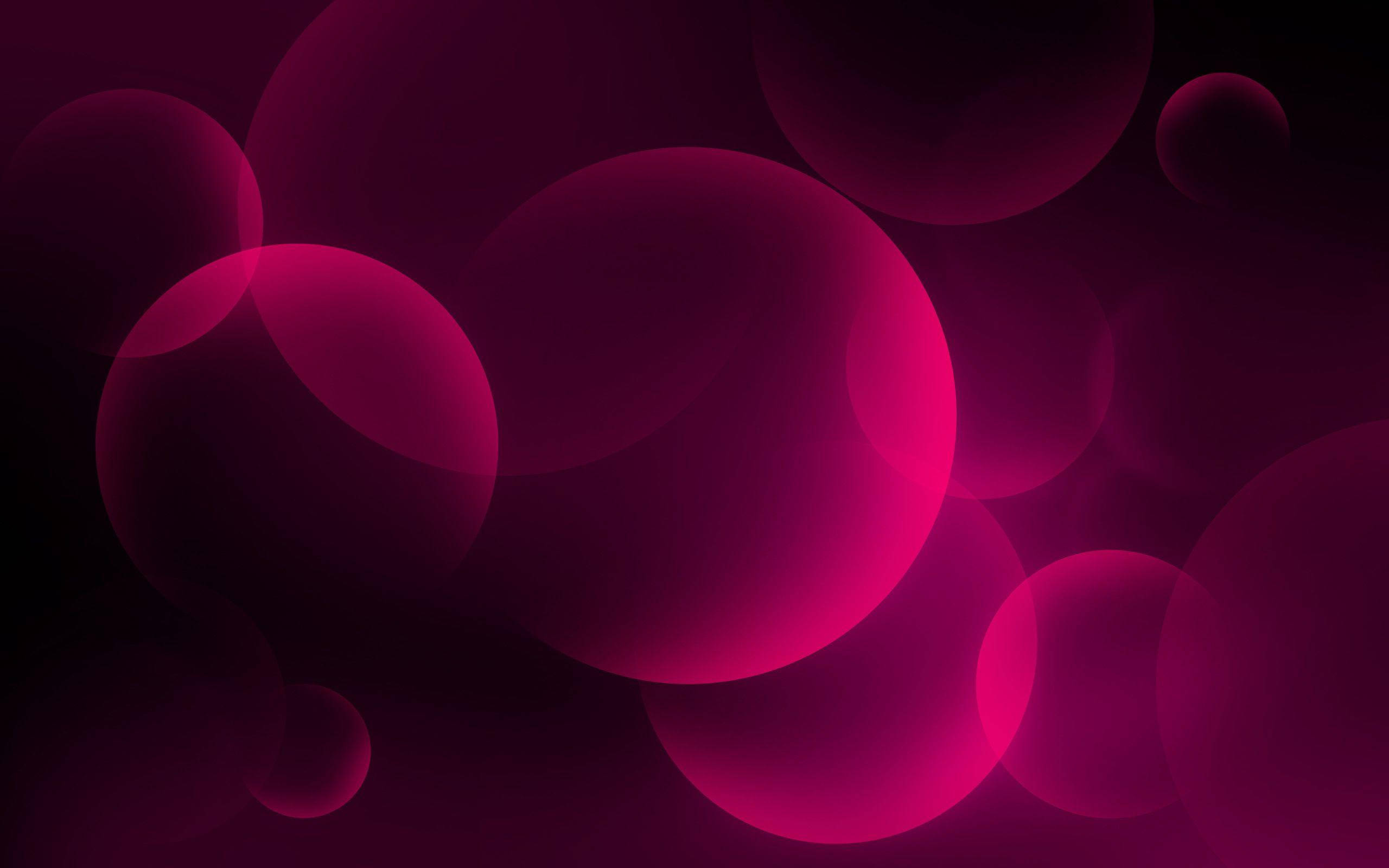 Circle 桌布 壁紙 — 充滿活力的洋紅色發光球體在深黑色背景上輕輕漂浮，營造出夢幻般的抽象光芒。