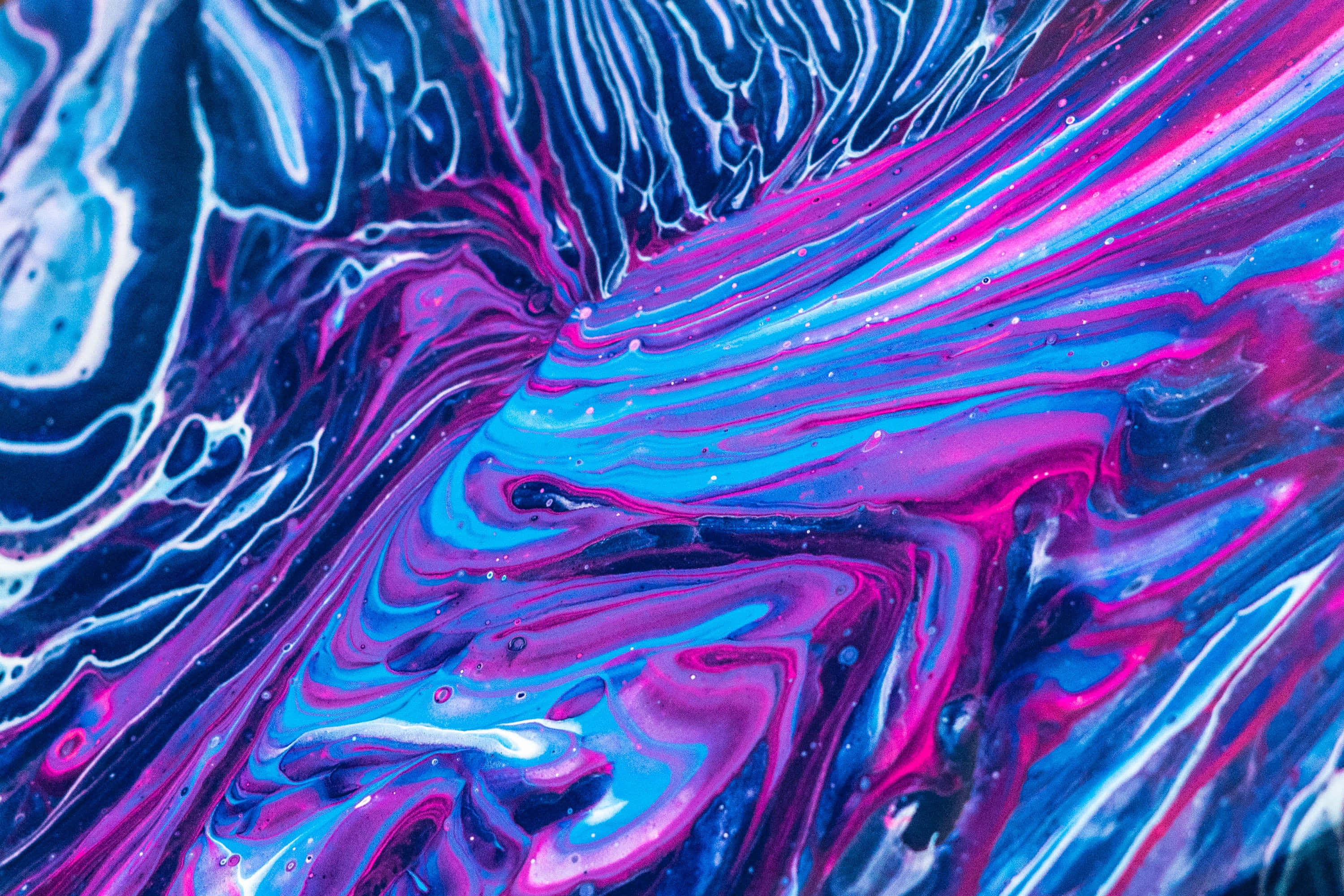 Purple Dye 桌布 壁紙 — 充滿活力的漩渦抽象圖案，採用電光藍和洋紅色顏料，帶有白色亮點和斑點。
