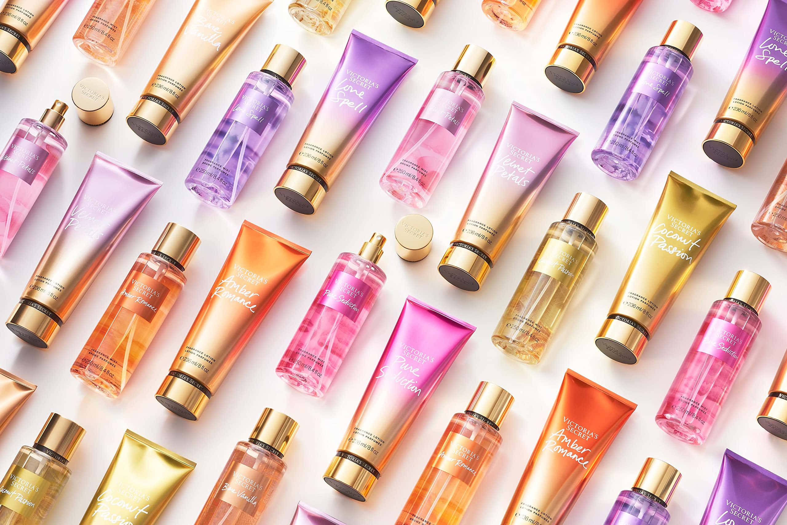 Victoria's Secret 桌布 壁紙 — 充滿活力的漸變色Victoria's Secret身體護理瓶，以粉紅、橙色和紫色排列成色彩繽紛的平鋪圖案。