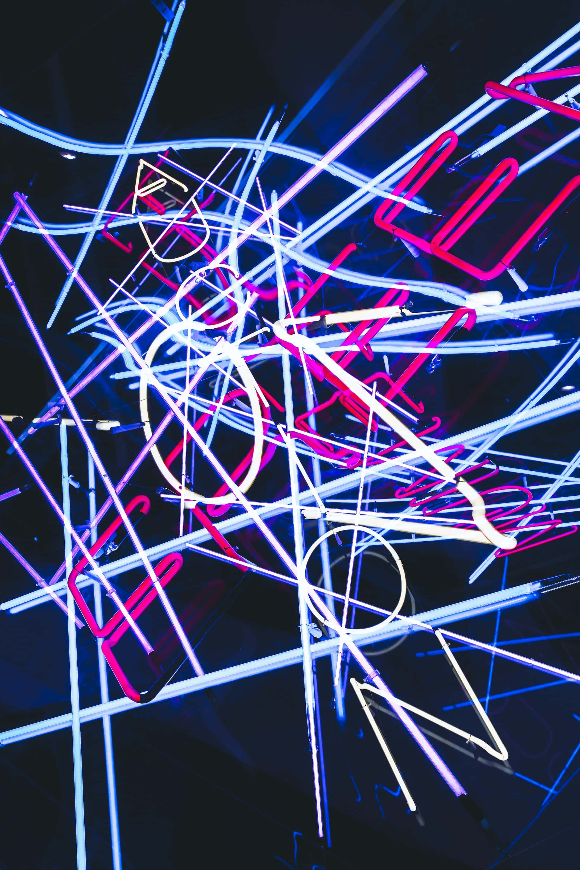 Psychedelic Neon Lights 桌布 壁紙 — 充滿活力的粉紅色、藍色和白色霓虹燈管在深色背景上交錯，營造出電光般的抽象光芒。