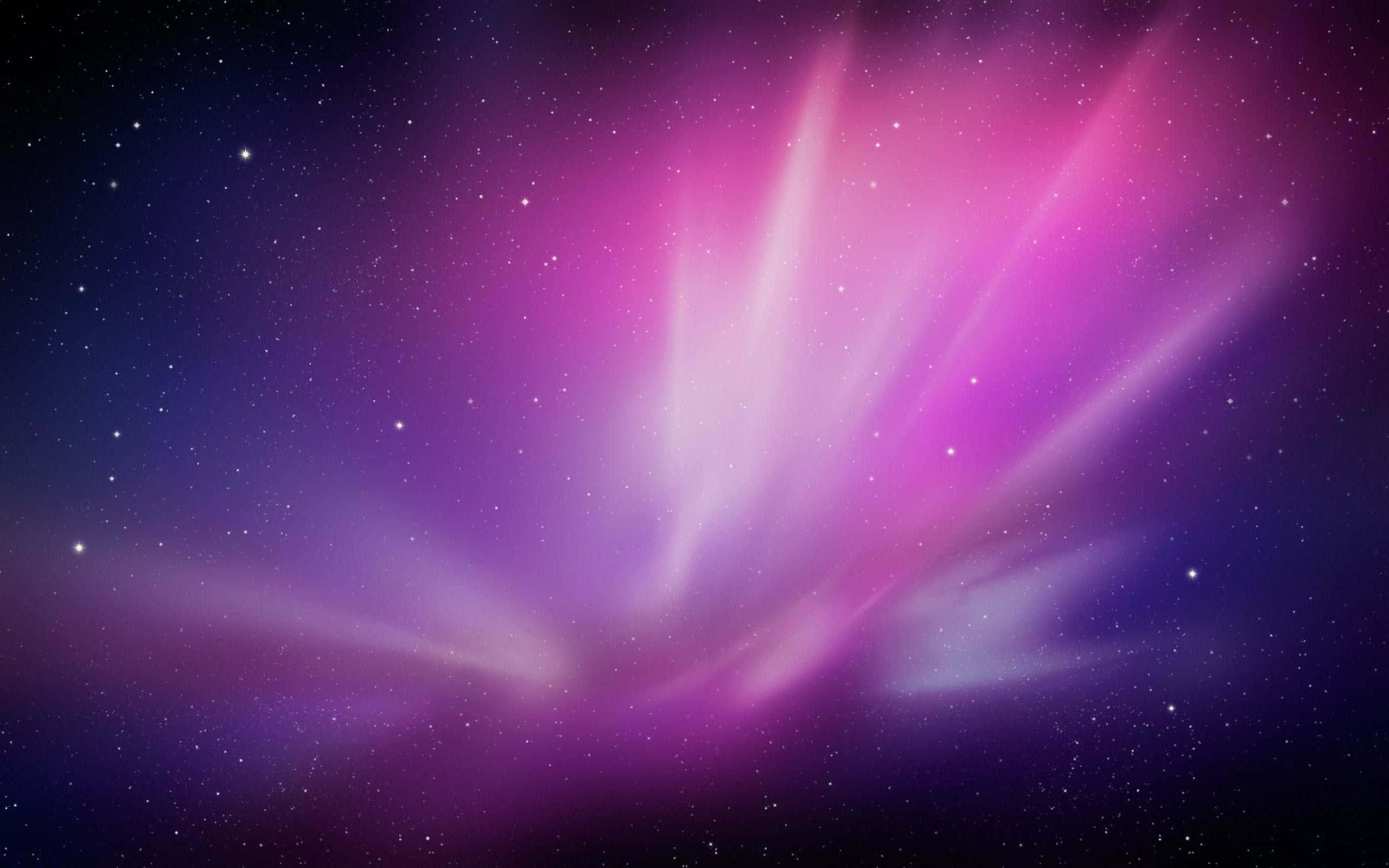 Pink Galaxy 桌布 壁紙 — 充滿活力的粉紅色和紫色宇宙射線從星場中爆發，形成迷人的太空場景。