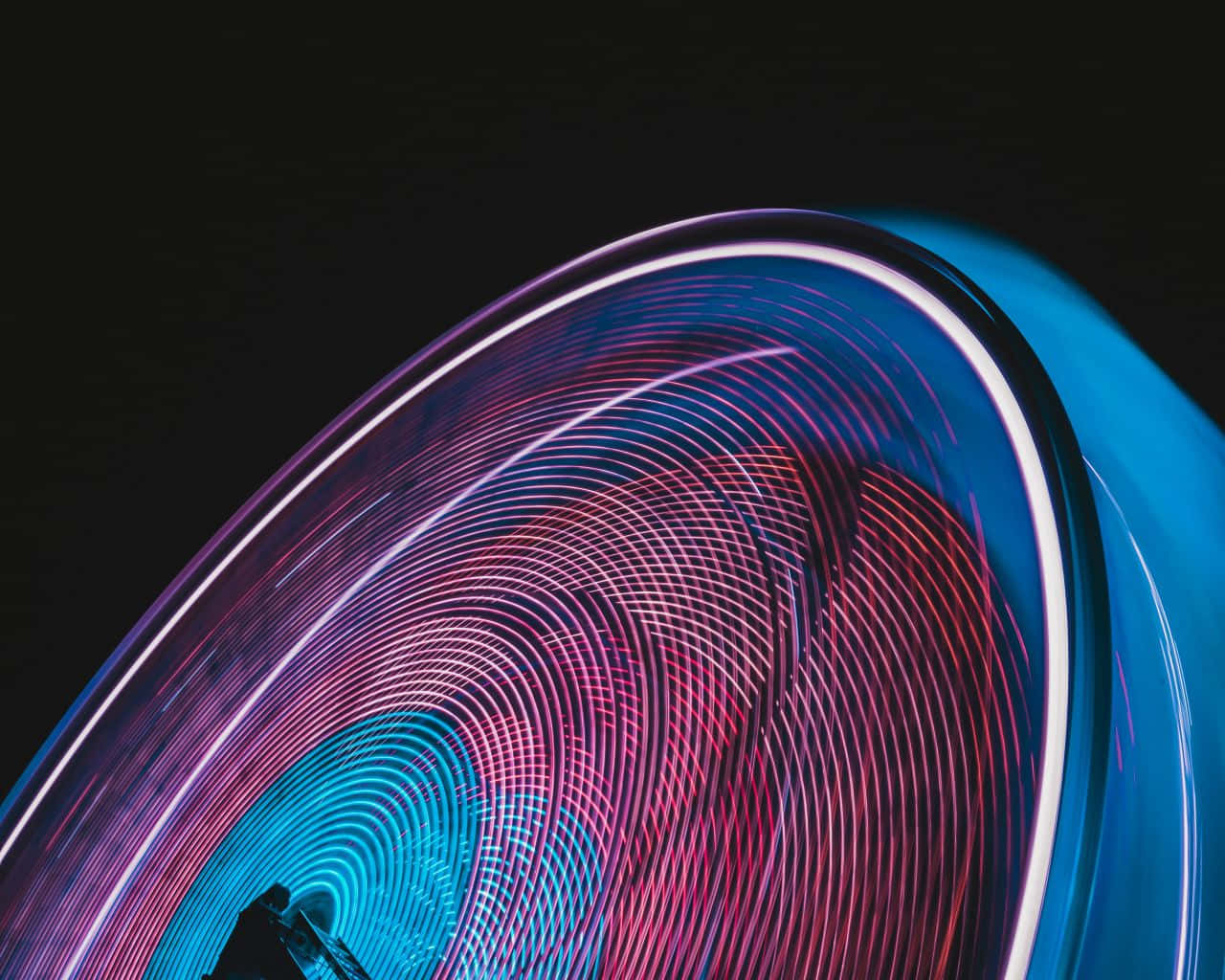 Motion Blur 桌布 壁紙 — 充滿活力的粉紅色和藍色旋轉光軌在深色背景上形成催眠般的螺旋。