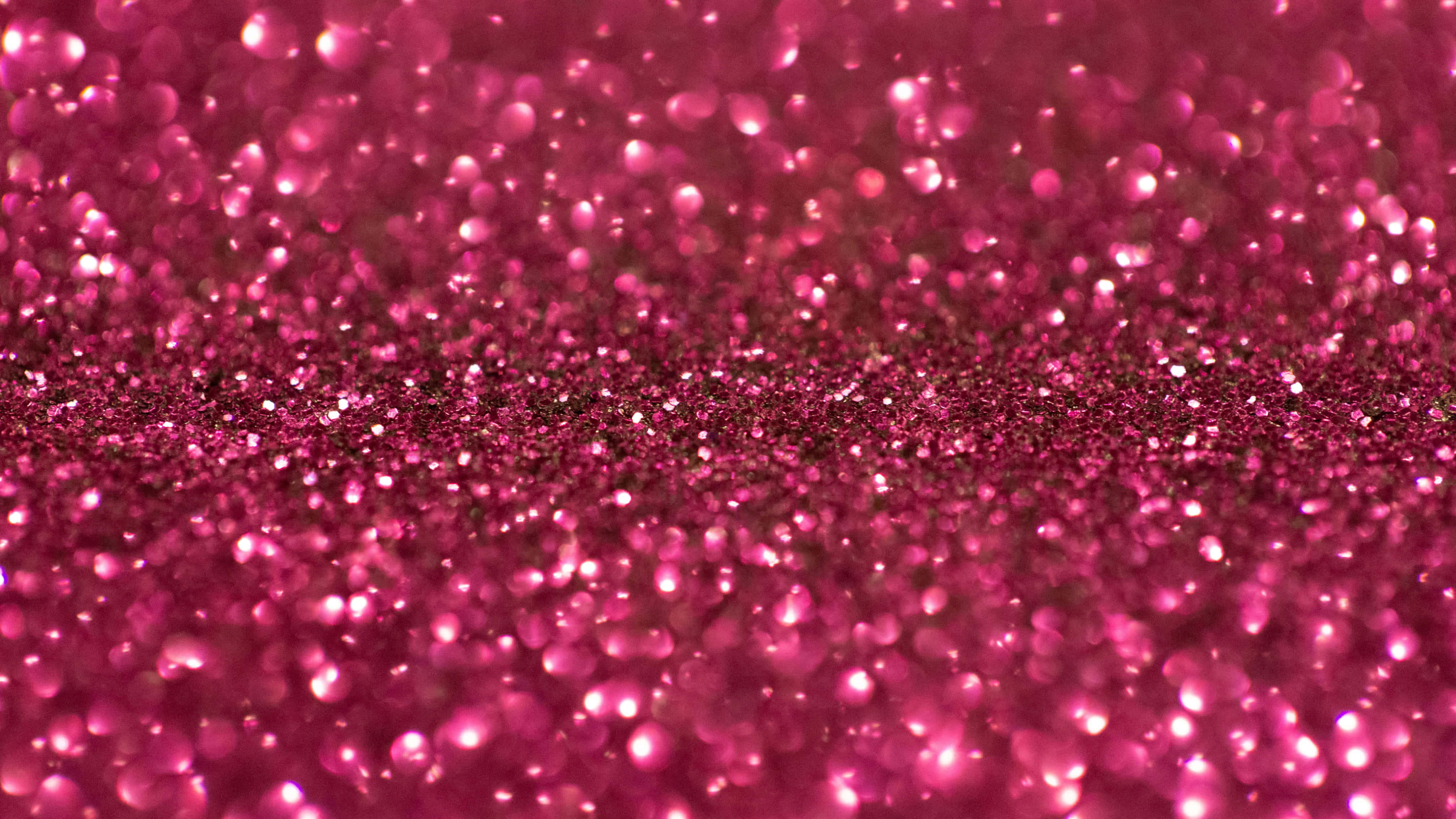 Pink Sparkle 桌布 壁紙 — 充滿活力的粉紅色閃粉特寫，帶有散景高光，營造出閃閃發光的紋理表面。