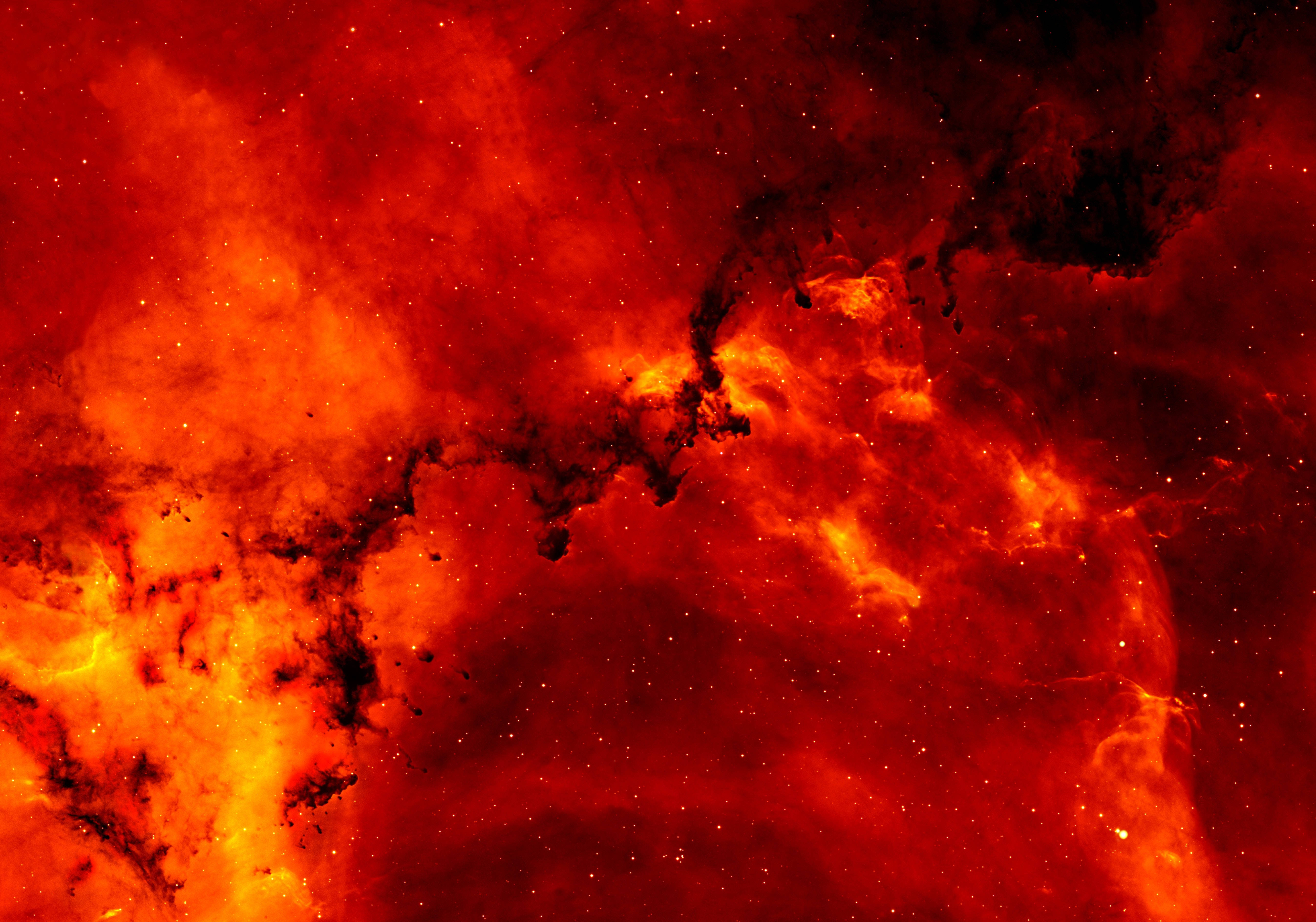  壁紙 — 充滿活力的紅色和橙色宇宙星雲，在黑暗虛空中呈現旋轉的氣體雲和散落的星星。