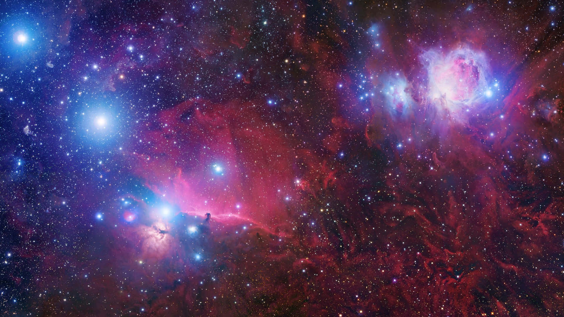 紫色銀河 桌布 壁紙 — 充滿活力的紅色和藍色宇宙雲層，明亮的星星散落在深邃的太空景觀中。