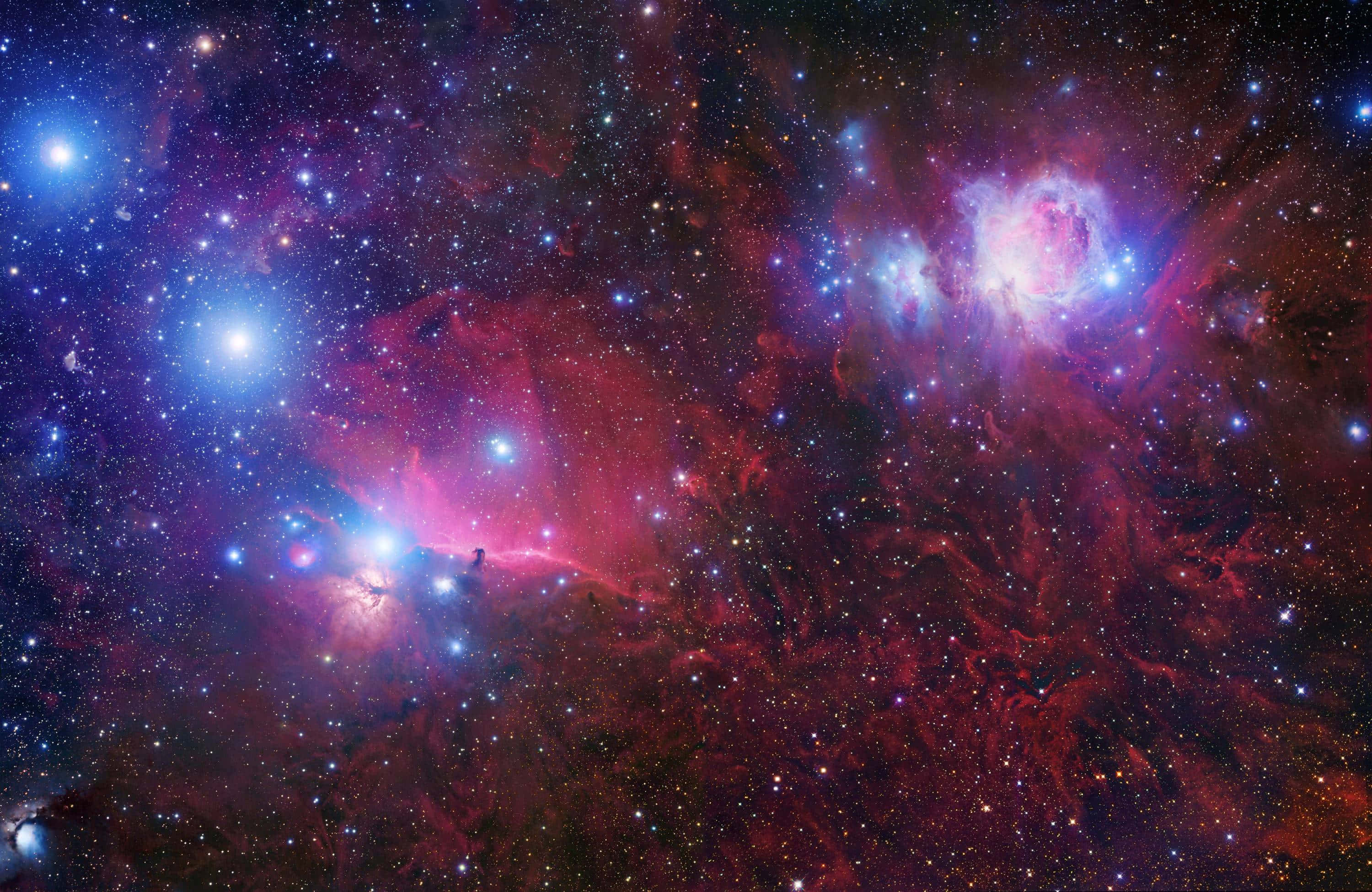 3d Star 桌布 壁紙 — 充滿活力的紅色和藍色宇宙雲層閃耀，明亮的星星散落在深邃的太空景觀中。