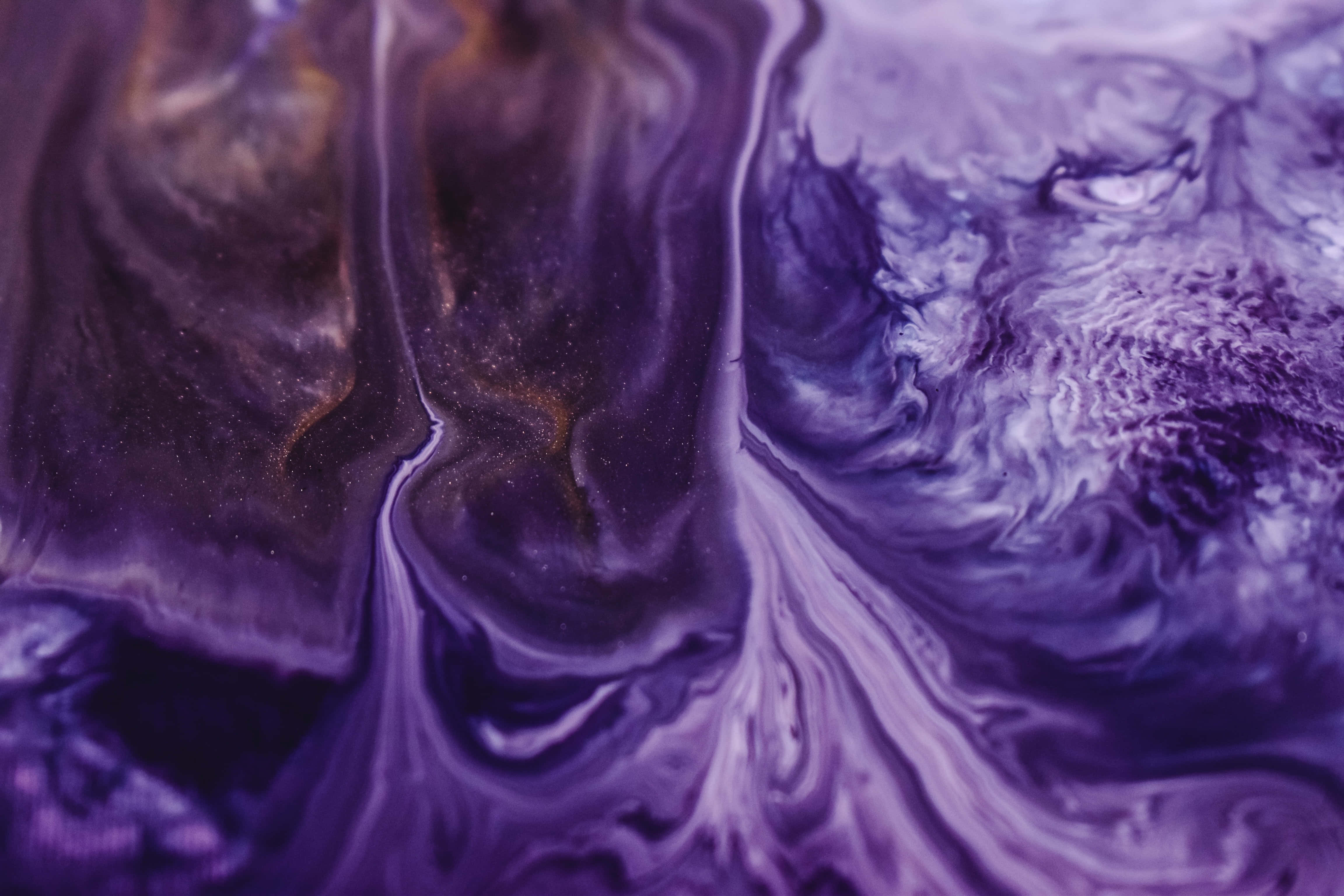 Purple Marble 桌布 壁紙 — 充滿活力的紫色和白色油漆在迷人的抽象流體圖案中旋轉，帶有金色斑點。
