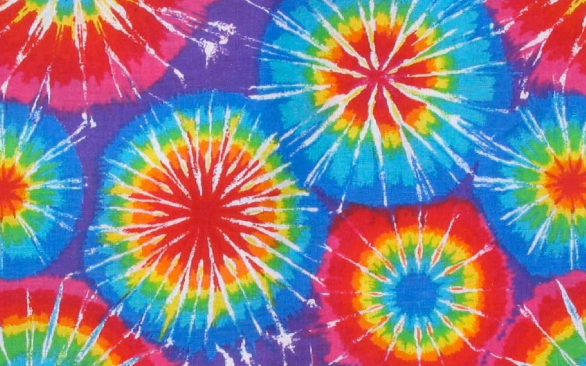 Pastel Tie Dye 桌布 壁紙 — 充滿活力的紮染圓圈在紫色背景上迸發出彩虹色調，形成迷幻圖案。