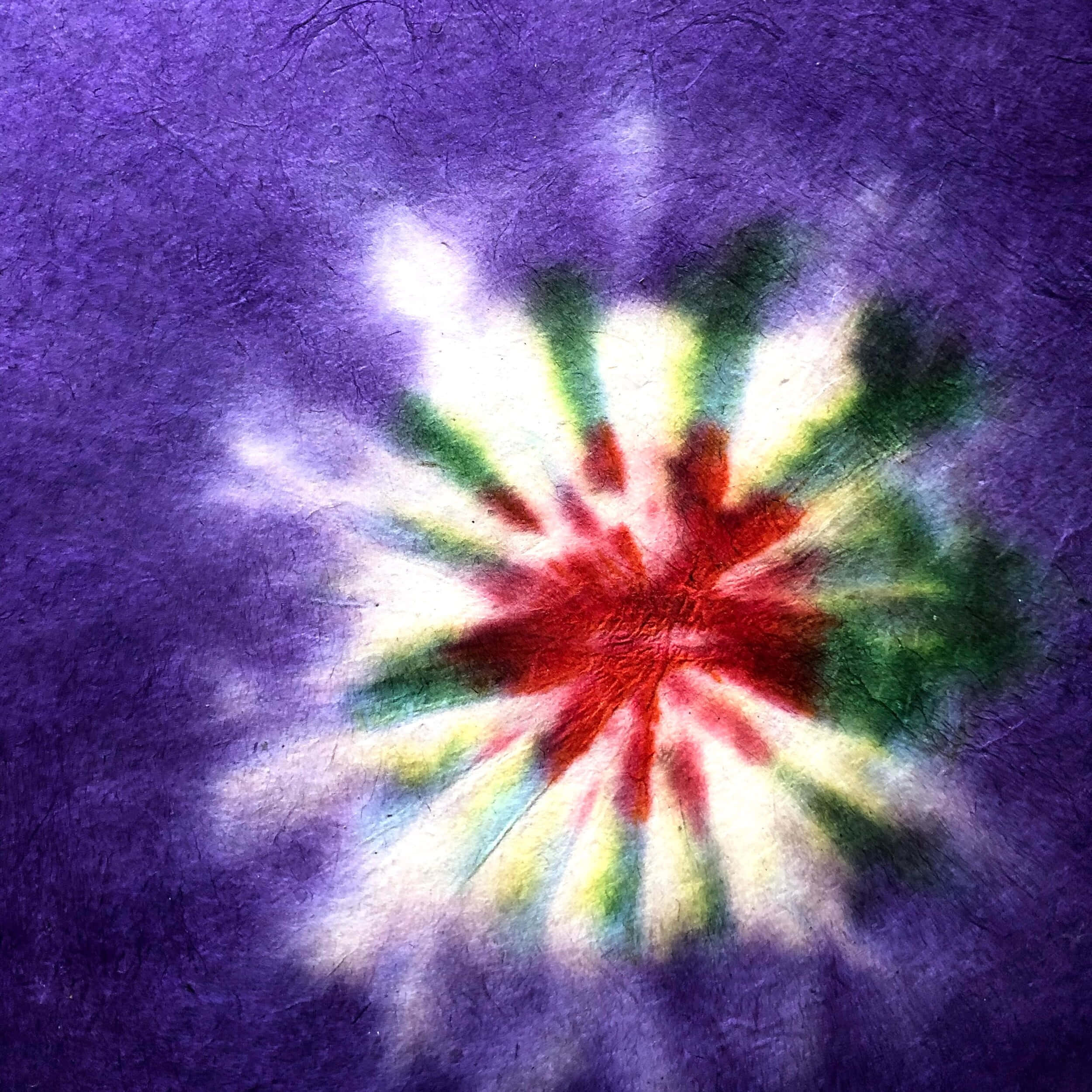 Purple Tie Dye 桌布 壁紙 — 充滿活力的紮染爆炸從紅色中心向帶有紋理的紫色背景輻射。