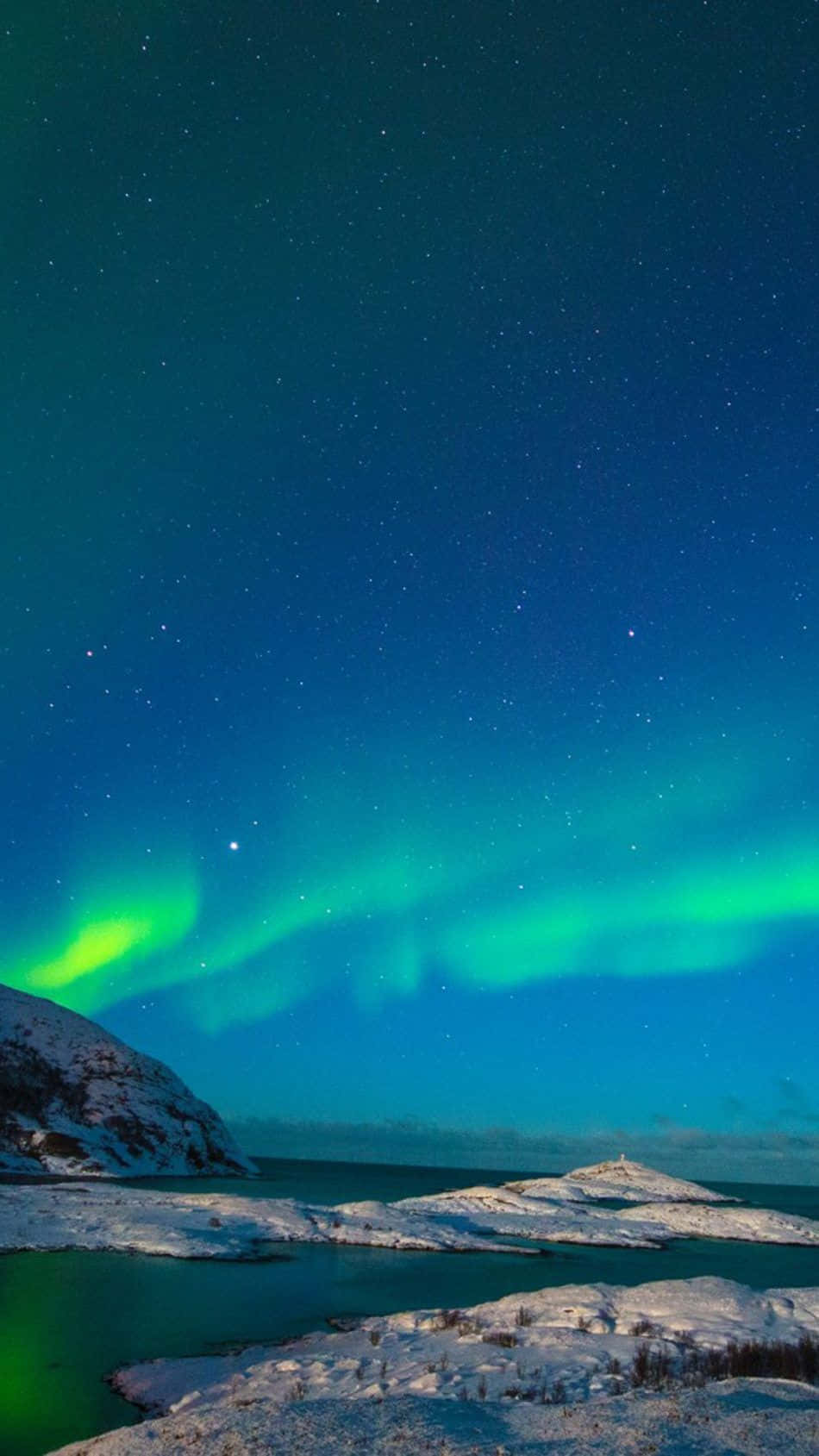 Norway 桌布 壁紙 — 充滿活力的綠色北極光在繁星點點的夜空中舞動，照耀著白雪覆蓋的北極凍原和冰冷的水域。