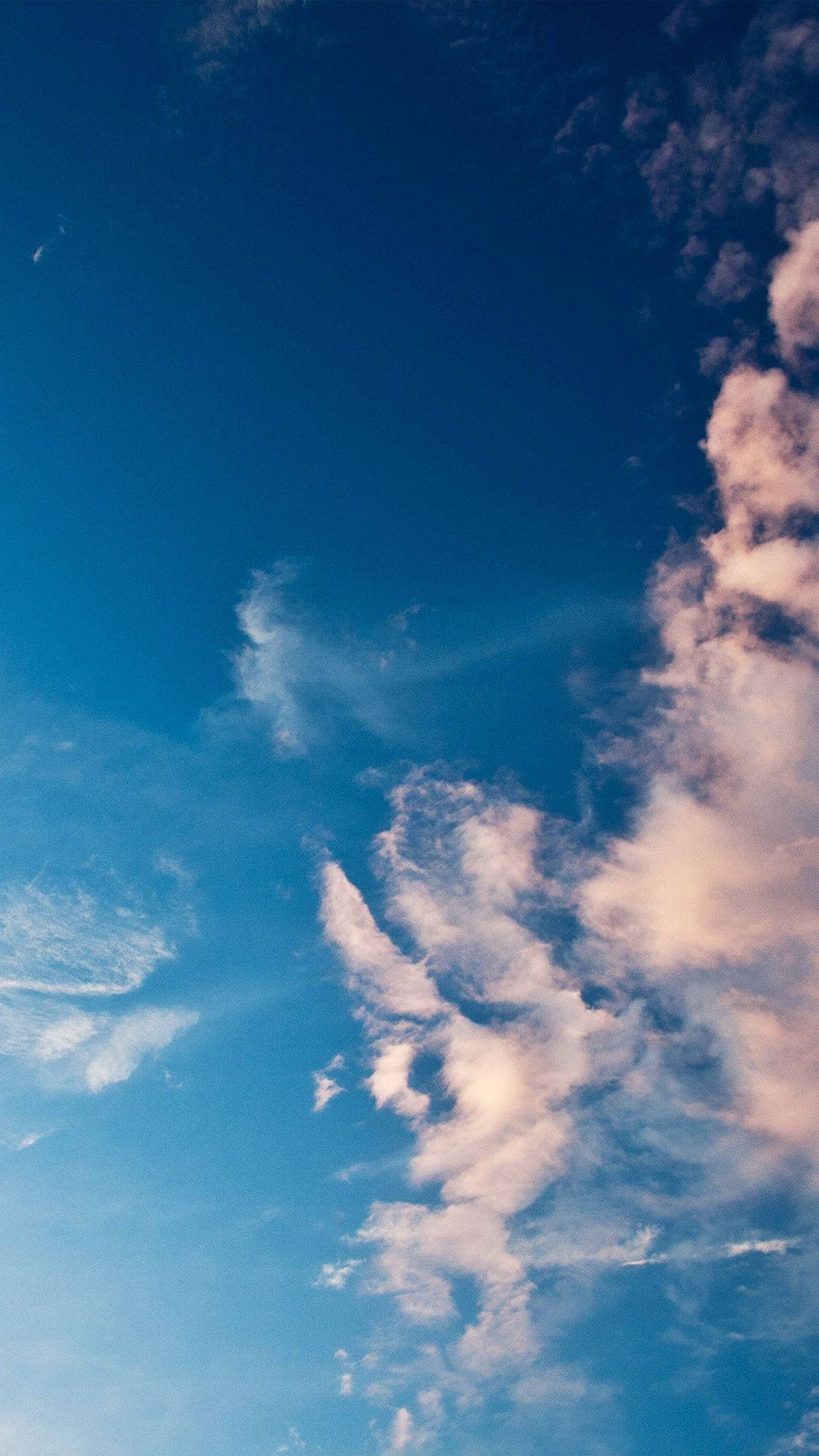 藍天 桌布 壁紙 — 充滿活力的藍天，帶有纖細的白雲，靠近地平線處染上柔和粉紅色調。