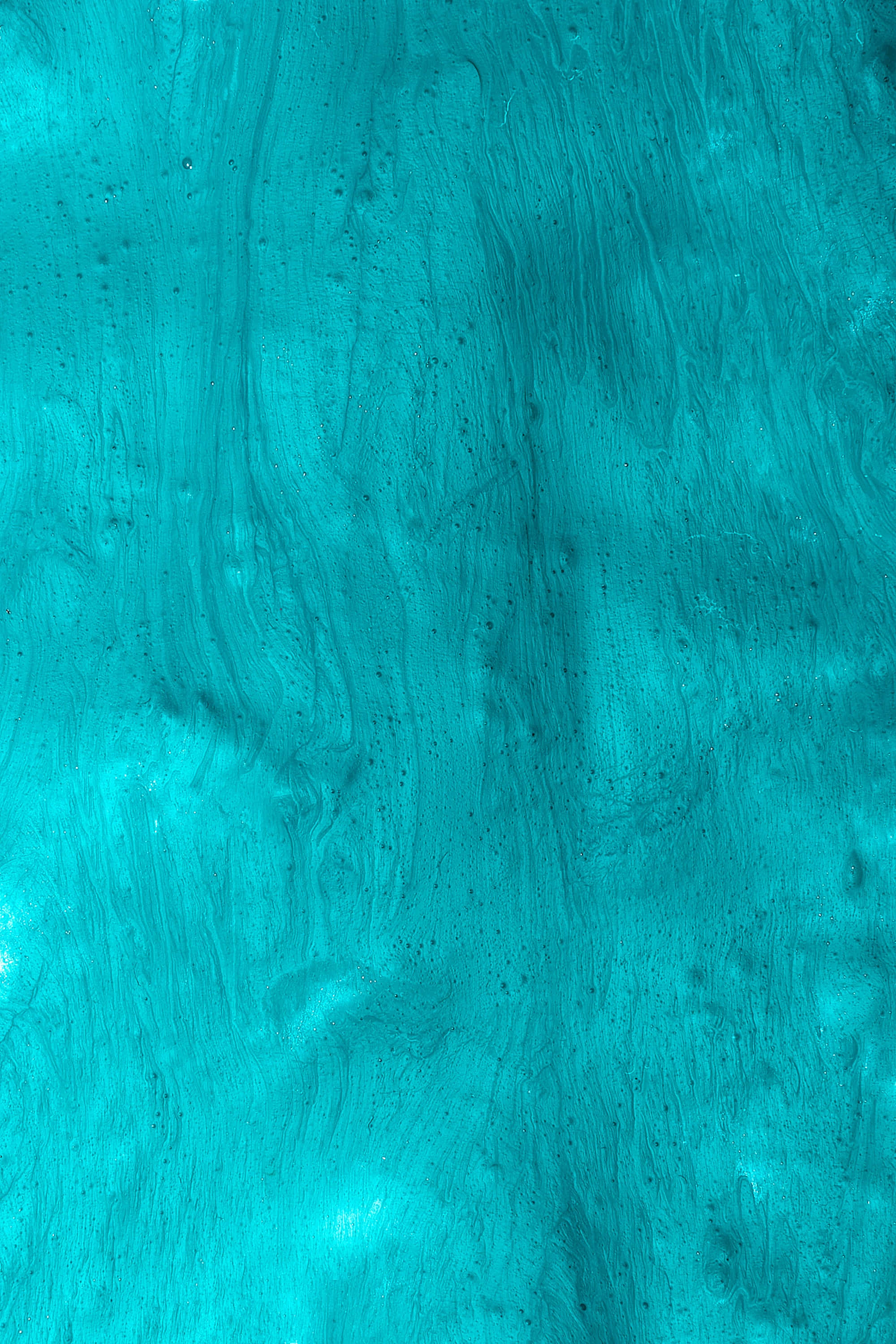 Turquoise Green 桌布 壁紙 — 充滿活力的藍綠色抽象紋理，帶有漩渦圖案和細微斑點，營造出動態流體表面。