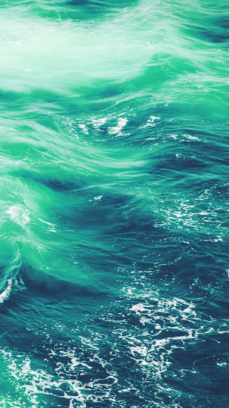 Seafoam Green 桌布 壁紙 — 充滿活力的藍綠色海浪與白色泡沫在洶湧海水的動態特寫中旋轉。