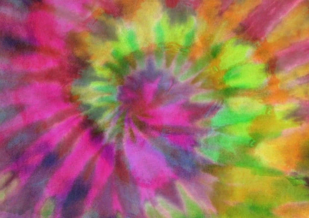 Pastel Tie Dye 桌布 壁紙 — 充滿活力的迷幻螺旋從中心輻射出來，霓虹粉紅、綠色、黃色和橙色色調在柔和模糊的運動中融合。