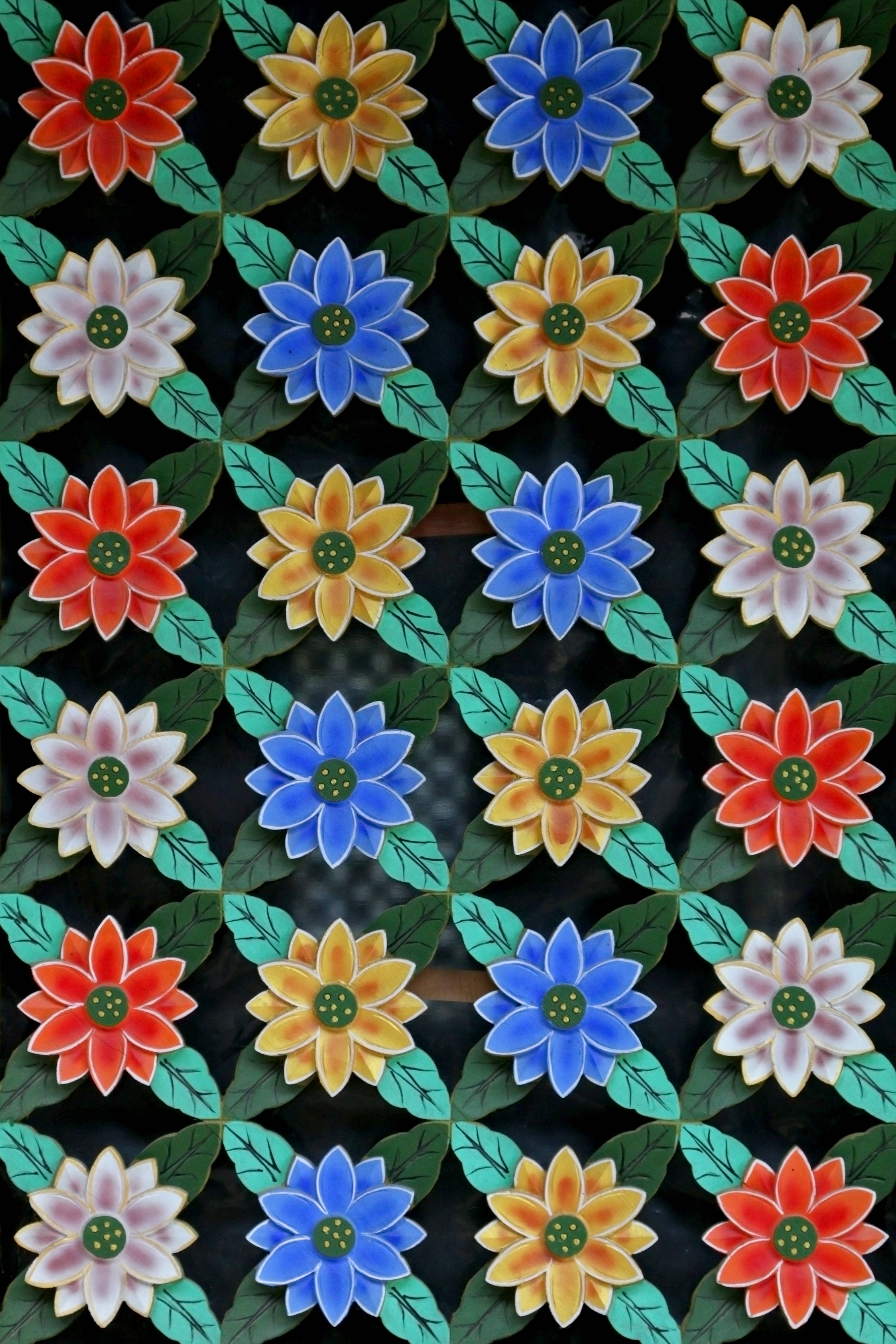 花卉動畫 桌布 壁紙 — 充滿活力的陶瓷磚展示重複的彩色花朵，有紅色、黃色、藍色和粉紅色，帶有綠色葉子，背景為深色。