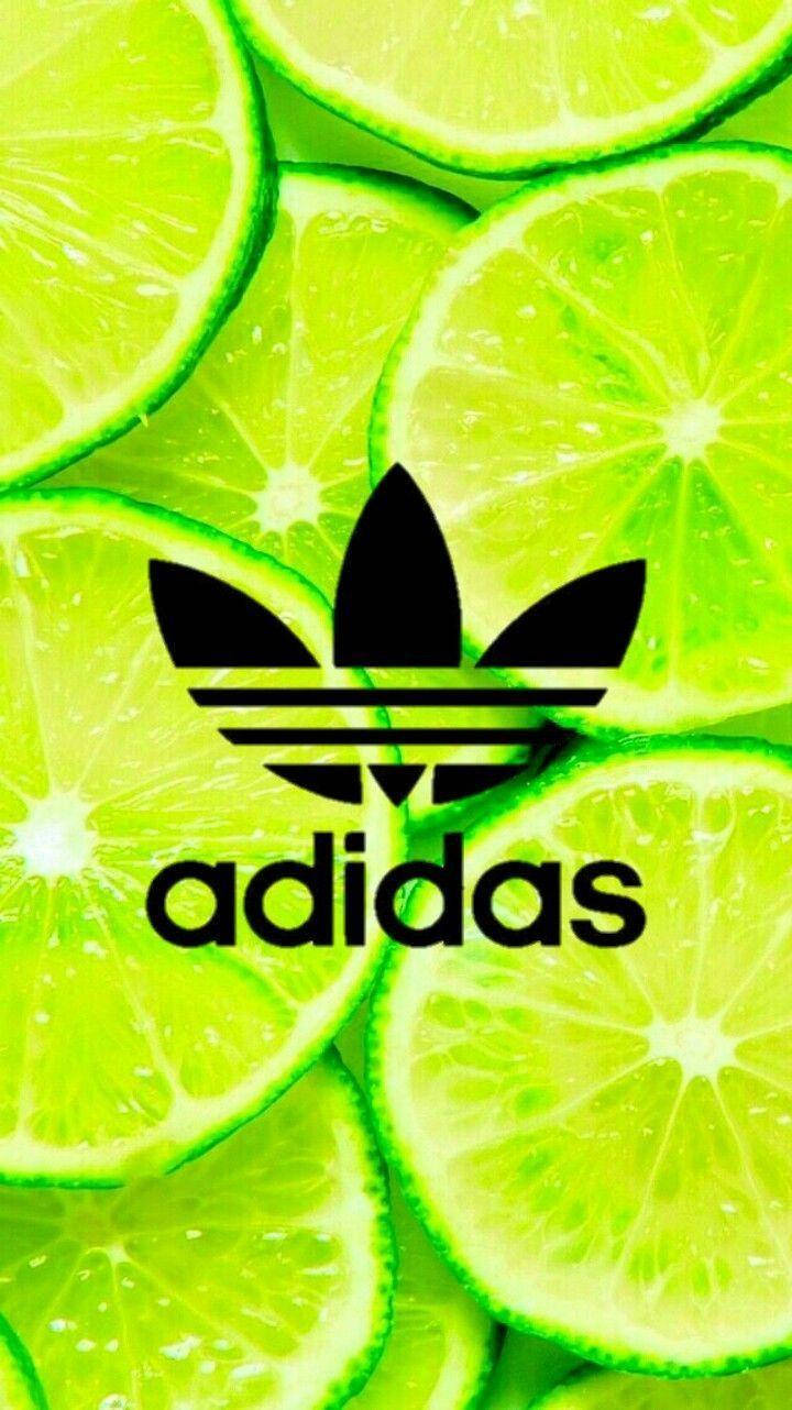 adidas iPhone 桌布 壁紙 — 充滿活力的青檸片為大膽的黑色Adidas標誌和文字形成多汁的背景。