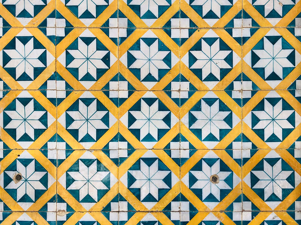 Beautiful Pattern 桌布 壁紙 — 充滿活力的黃色和藍綠色幾何瓷磚在風化的牆壁上形成重複的星星圖案。