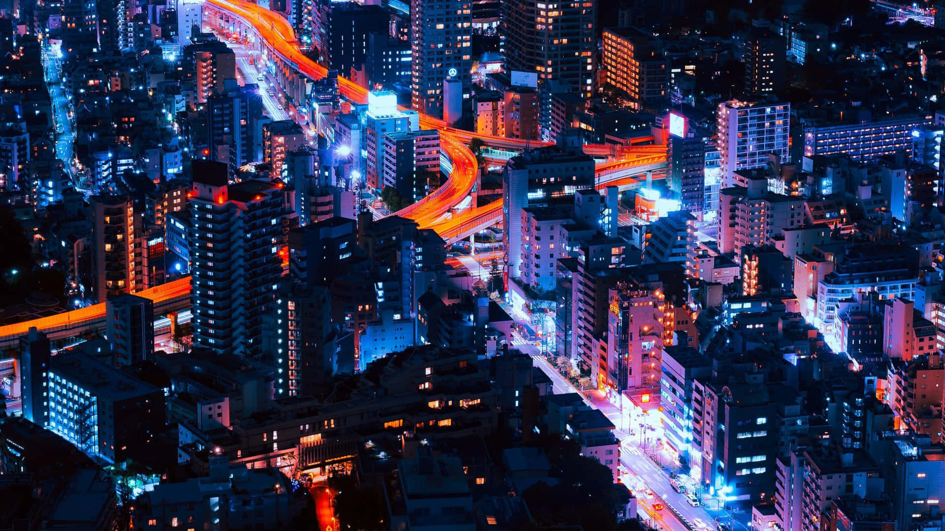 夜晚鳥瞰發光的城市景觀，霓虹燈和高速公路。