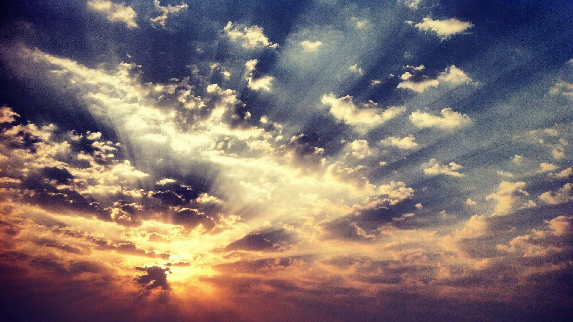 日落天空，金色光線穿透戲劇性的雲層。