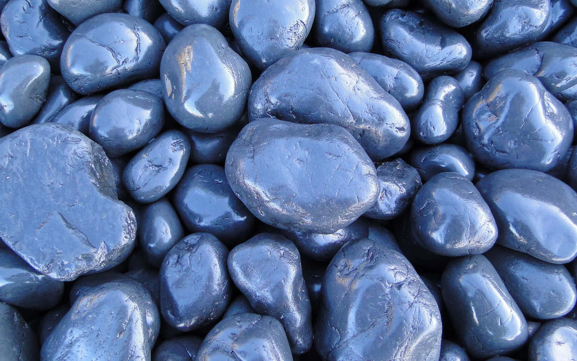Slate Blue 桌布 壁紙 — 光滑藍灰色河石的近距離特寫，在柔和光線下閃爍著水氣。