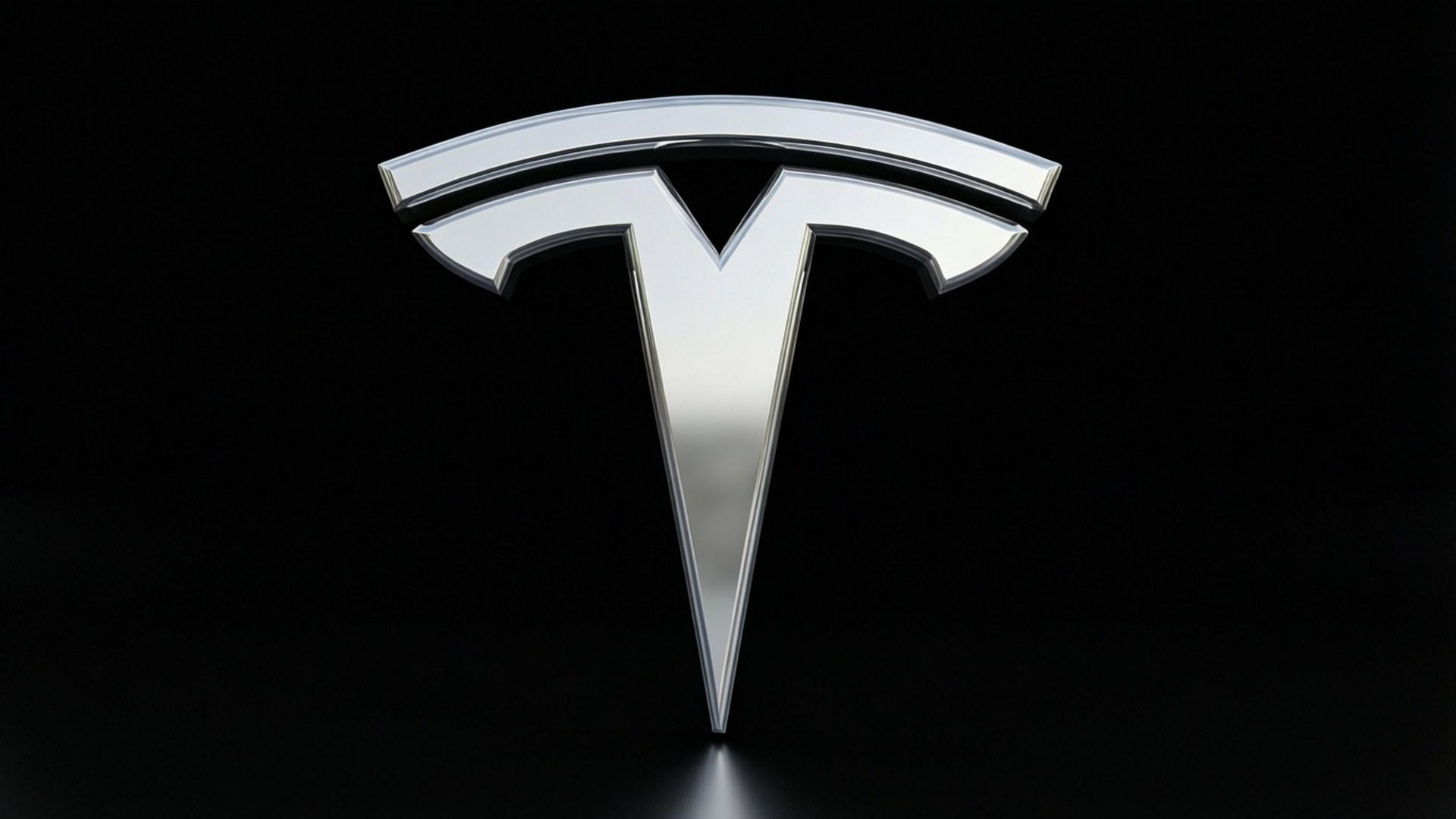 光澤Tesla標誌 壁紙 — 一個時尚的鉻色Tesla標誌居中放置在純黑色背景上，下方有柔和倒影。