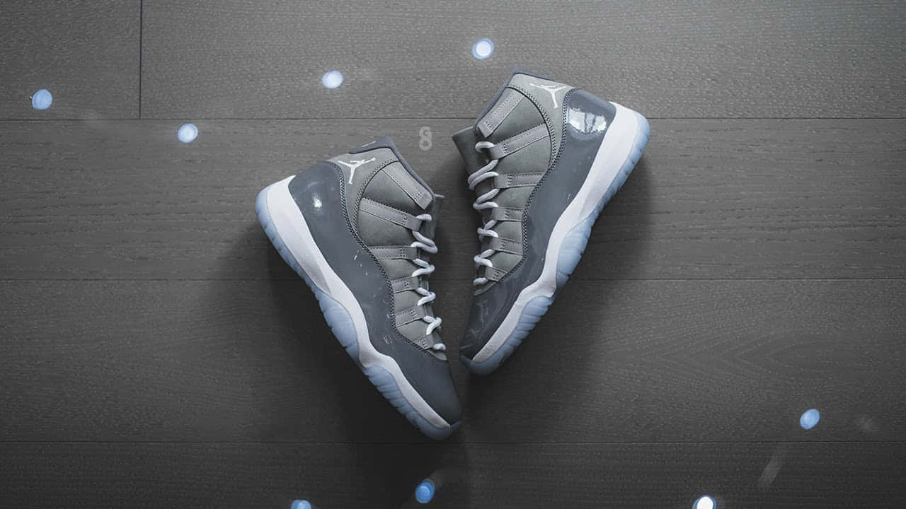 灰色Jordan 11波鞋在深色木上以藍光形成心形。