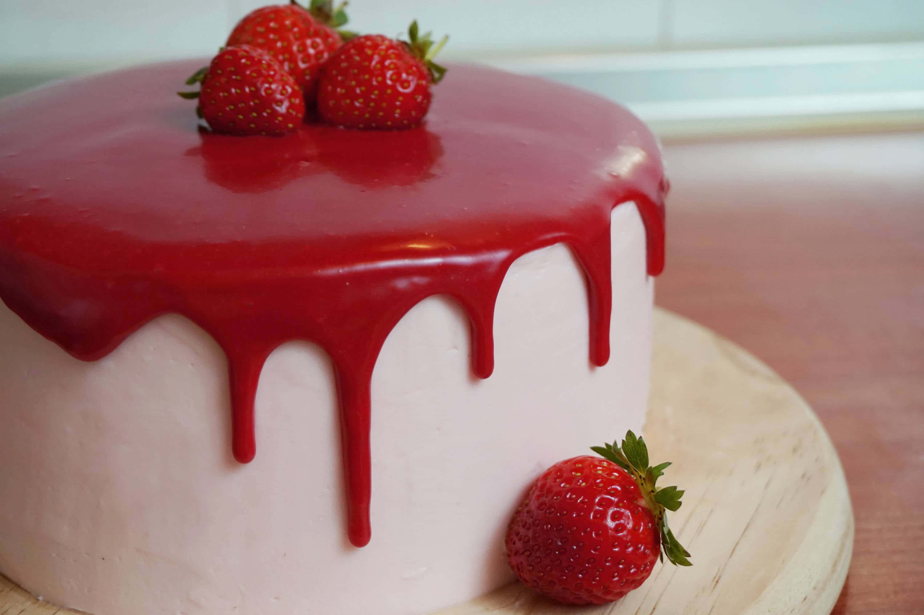 Red Velvet Cake 桌布 壁紙 — 光澤的紅色草莓糖霜誘人地滴落在白色糖霜蛋糕上，上面放著新鮮草莓。