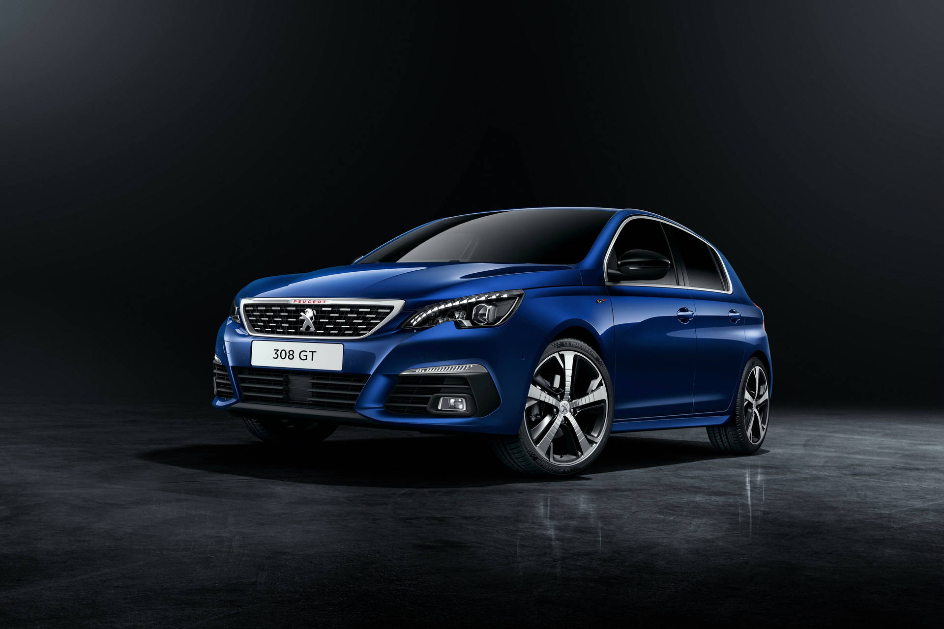 藍色Peugeot 308 GT跑車在攝影棚中，地板反光。