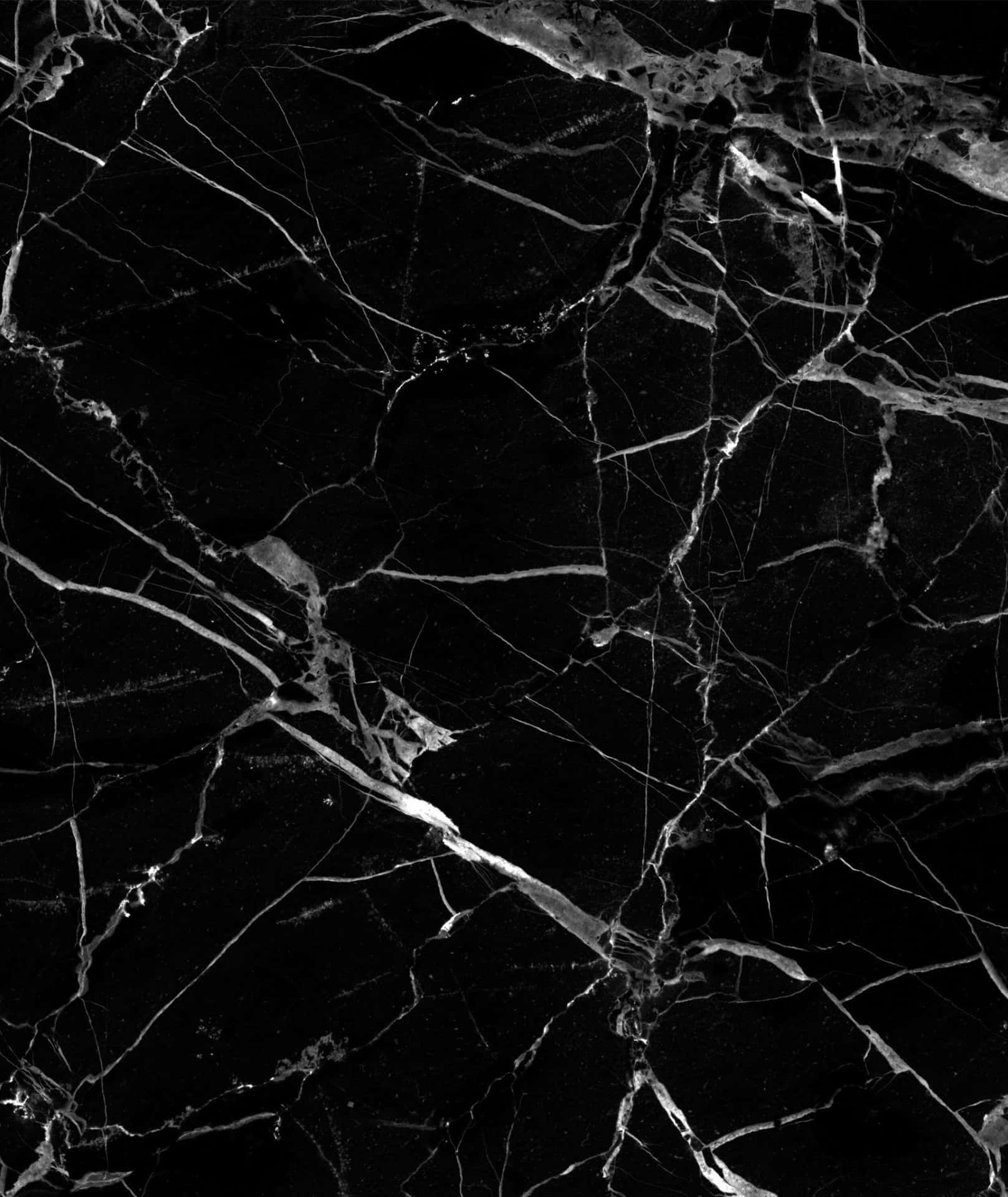 Marble iPhone 桌布 壁紙 — 光澤黑色大理石的近距離特寫，帶有複雜的銀色紋理，形成戲劇性的自然圖案。