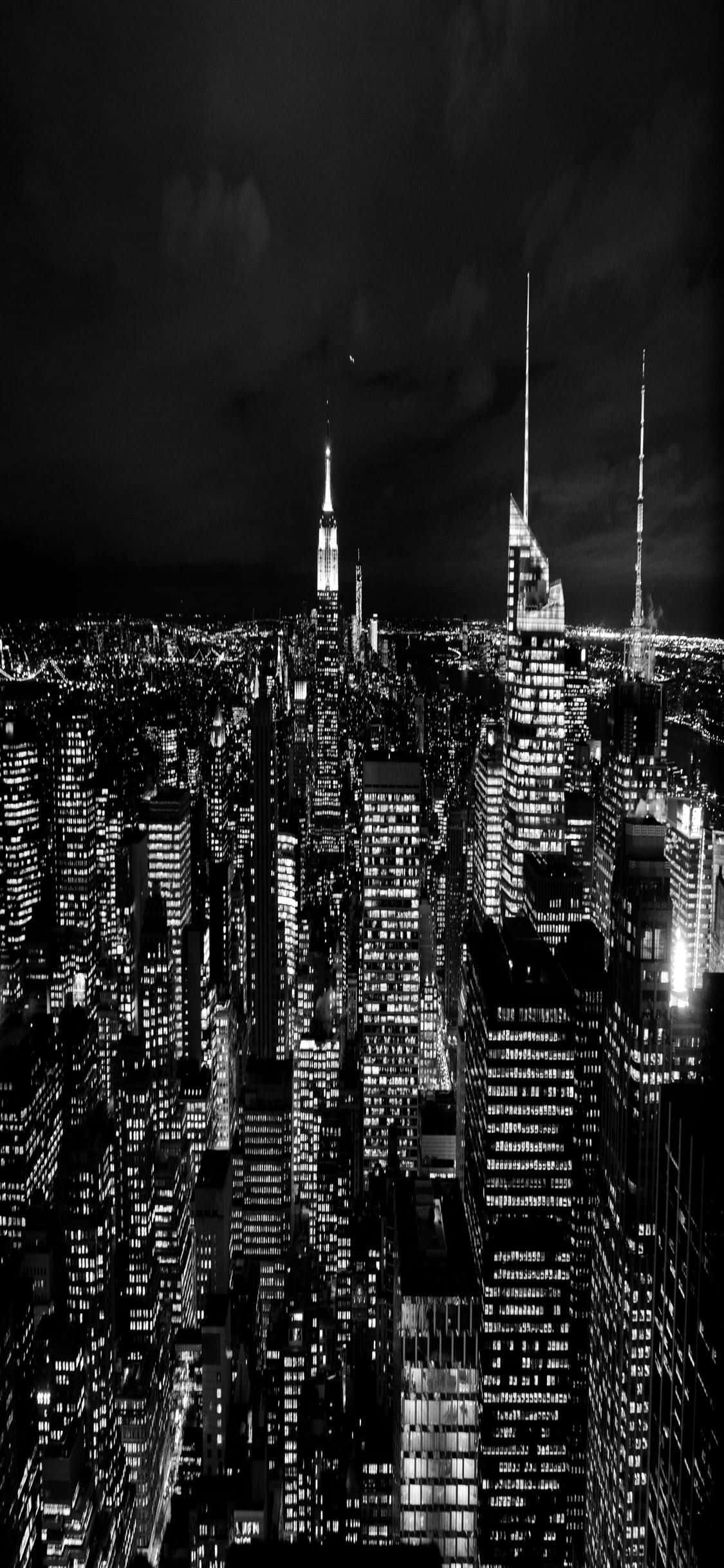 密集城市的夜間航拍視圖，摩天大樓在黑暗的天空中閃閃發光。