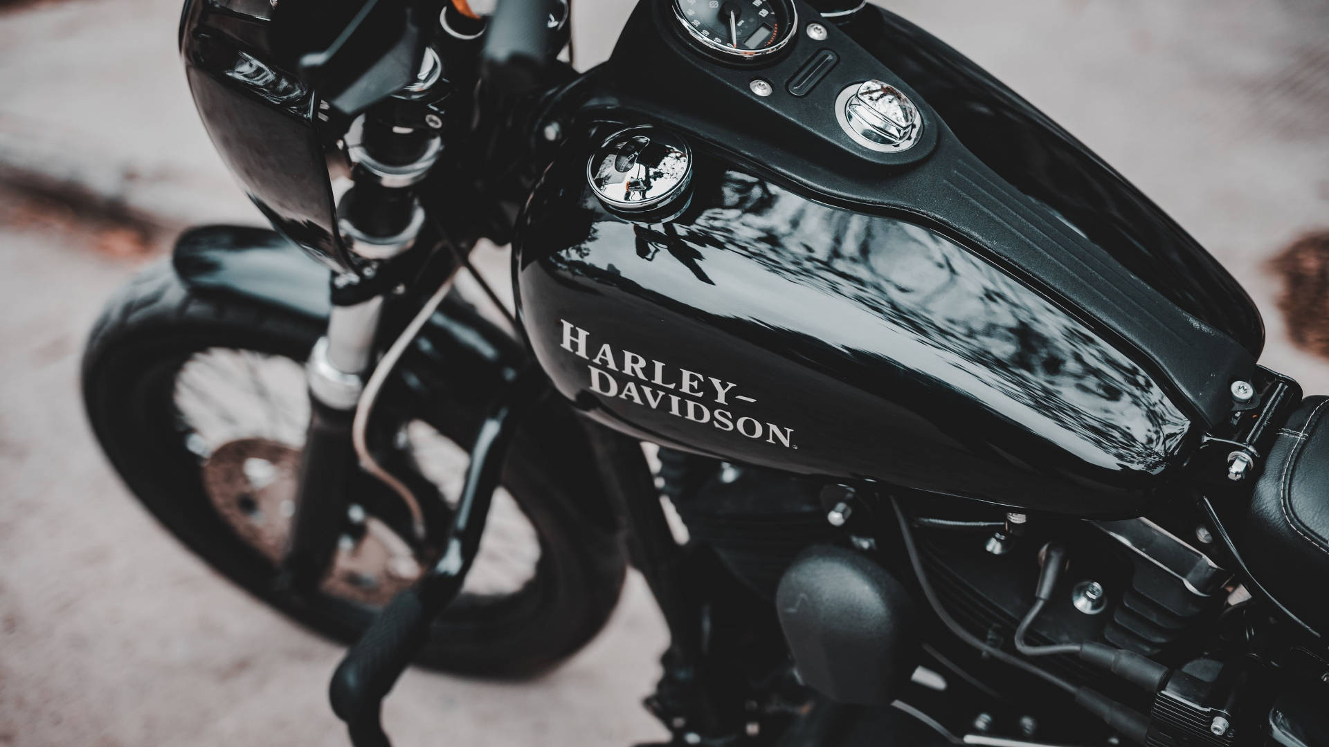 機車 桌布 壁紙 — 光面黑色Harley-Davidson電單車油缸特寫，反射樹木和天空，帶有鍍鉻裝飾。