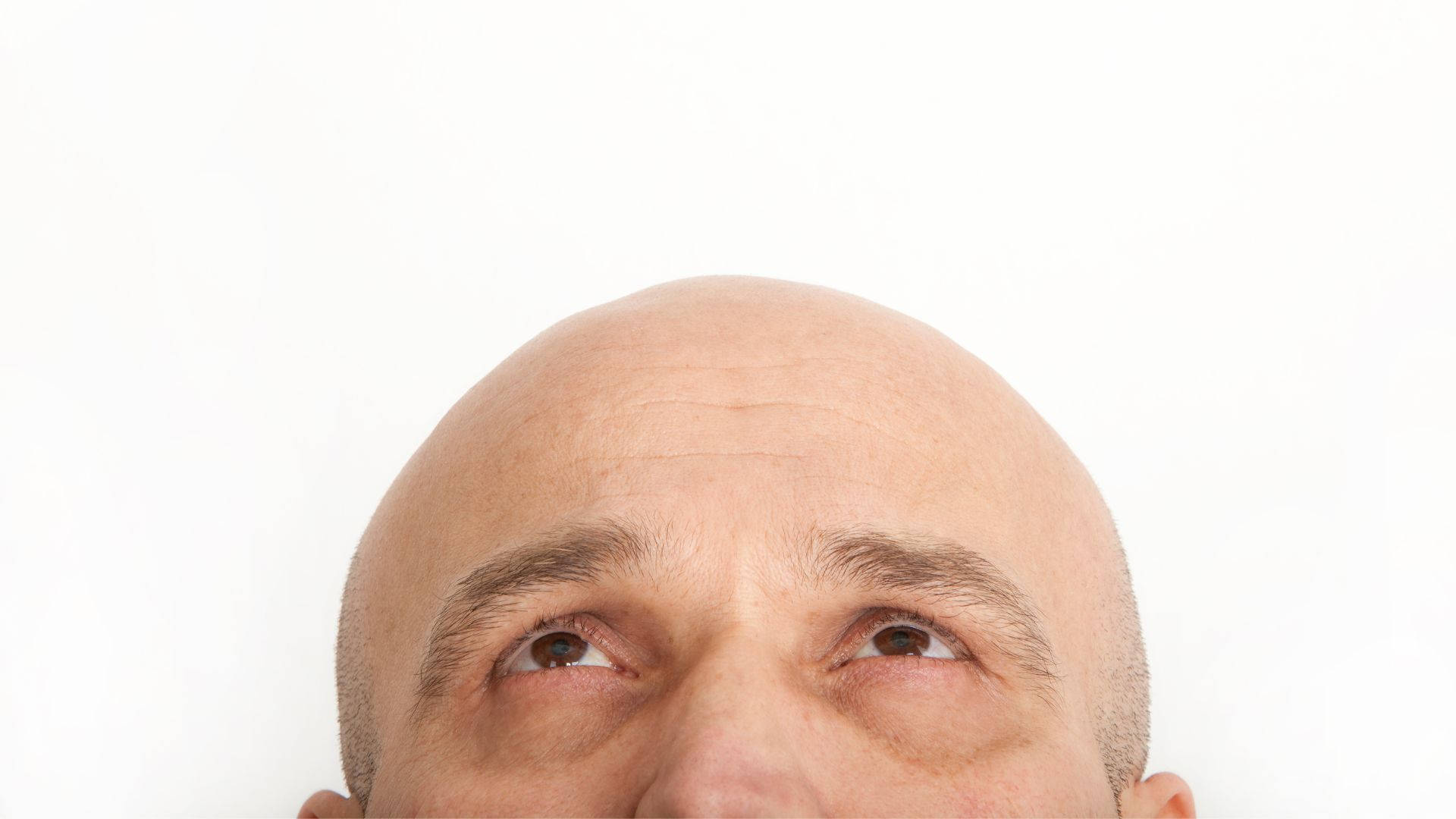 光頭男人眼睛向上望的特寫。