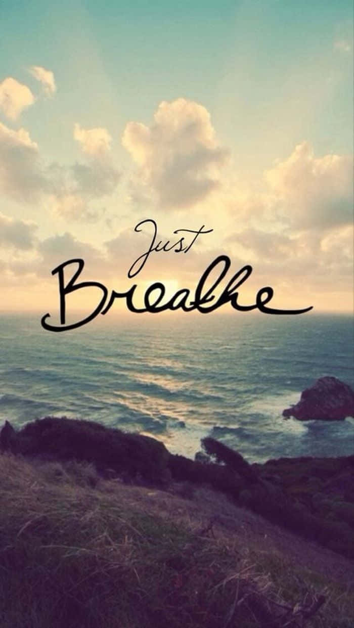 海岸日落場景，文字 just breathe 覆蓋在海洋和天空上。