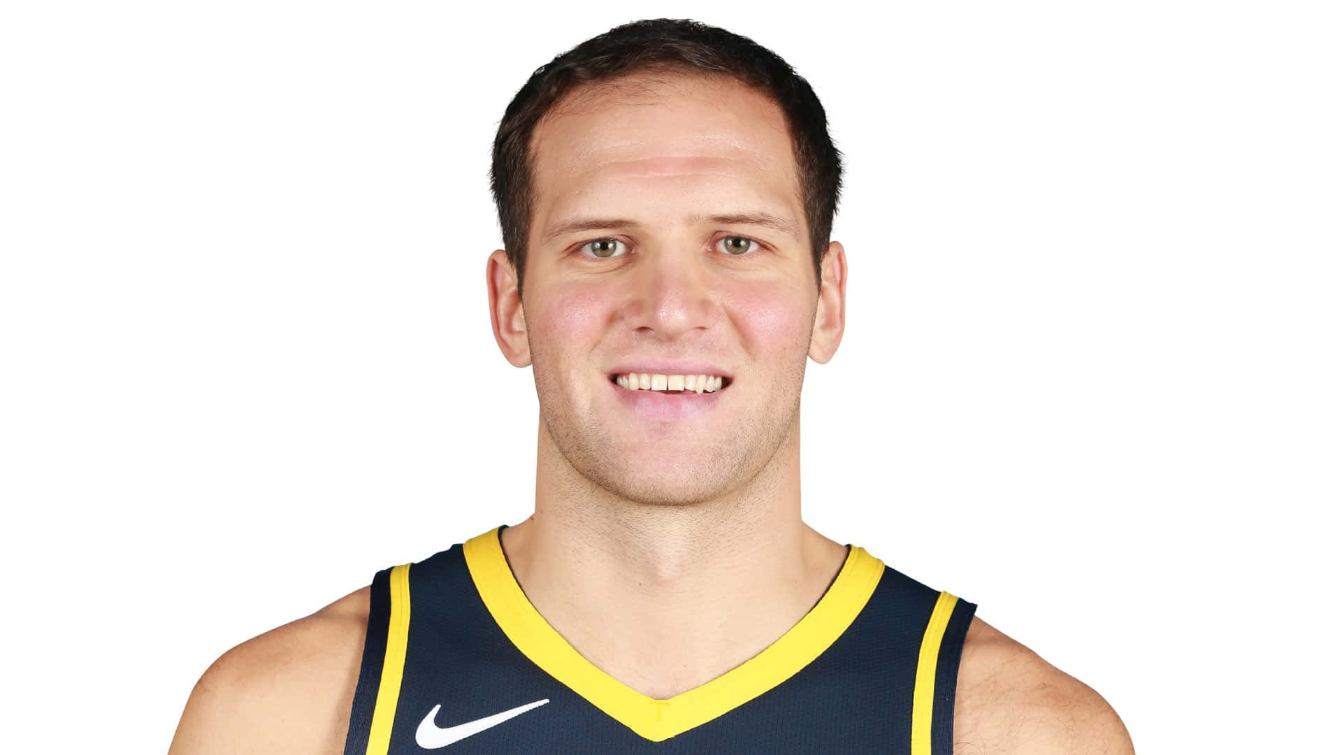 克羅地亞NBA球員 波揚·博格丹諾維奇 壁紙 — 一位身穿海軍藍和黃色球衣的籃球運動員微笑著在白色背景前擺姿勢。