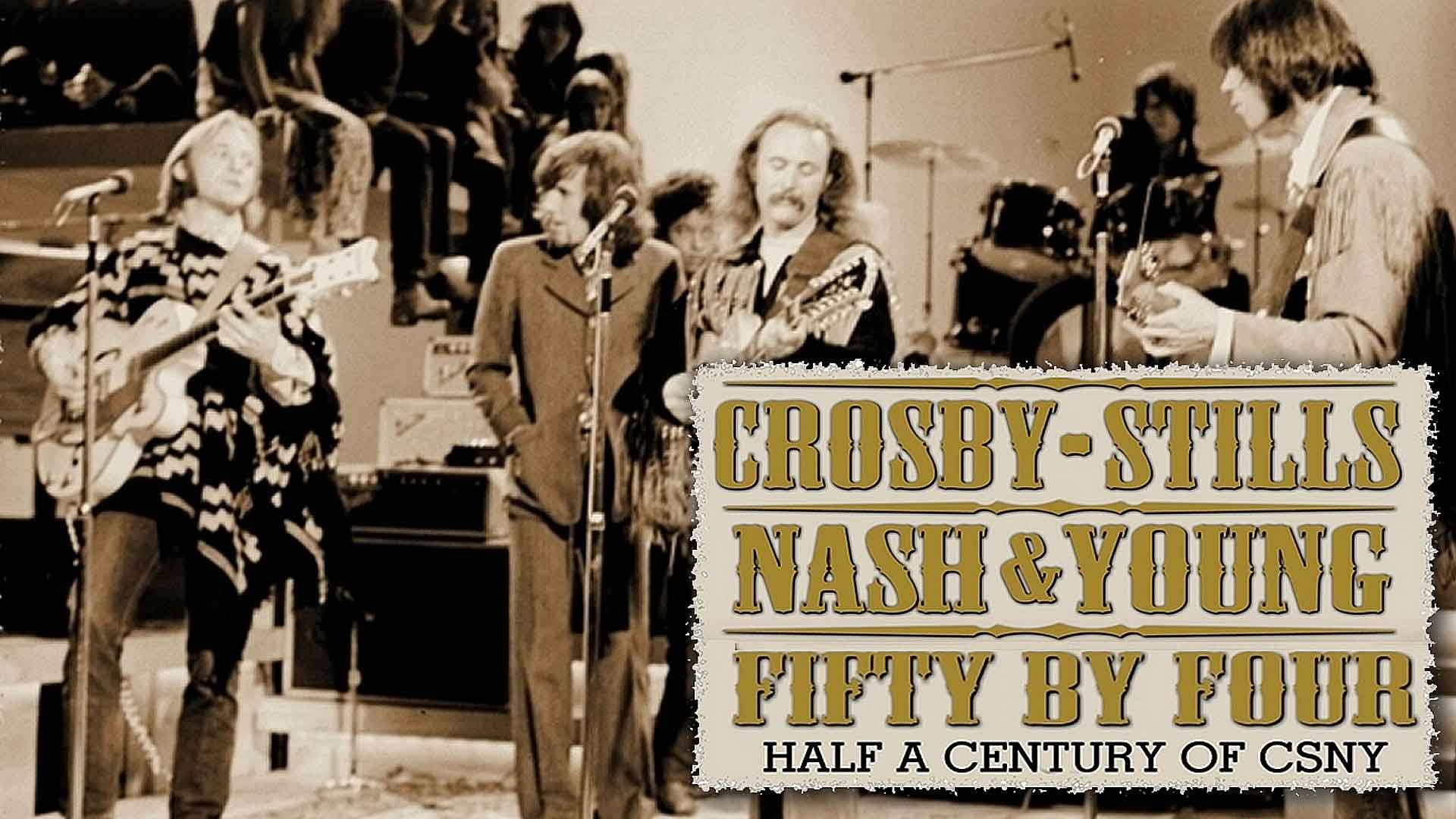 Crosby Stills Nash & Young 在舞台上用結他和擴音器現場表演。